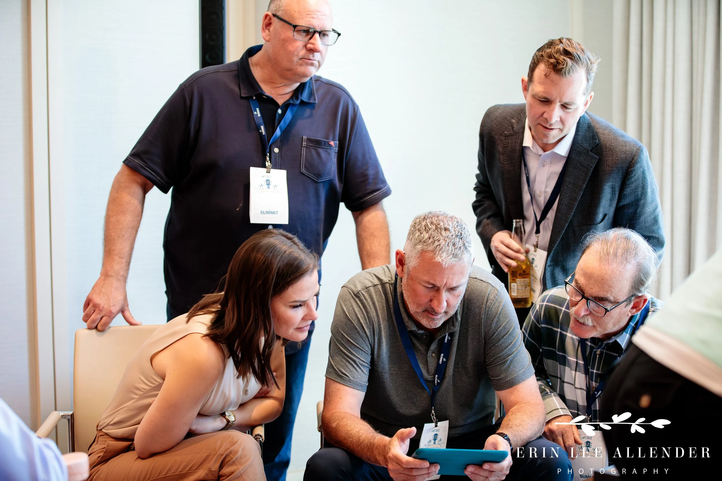 Nashville conference photographer — team looking at iPad instructions during CBIZ Nashville Summit Guitars for Vets guitar build