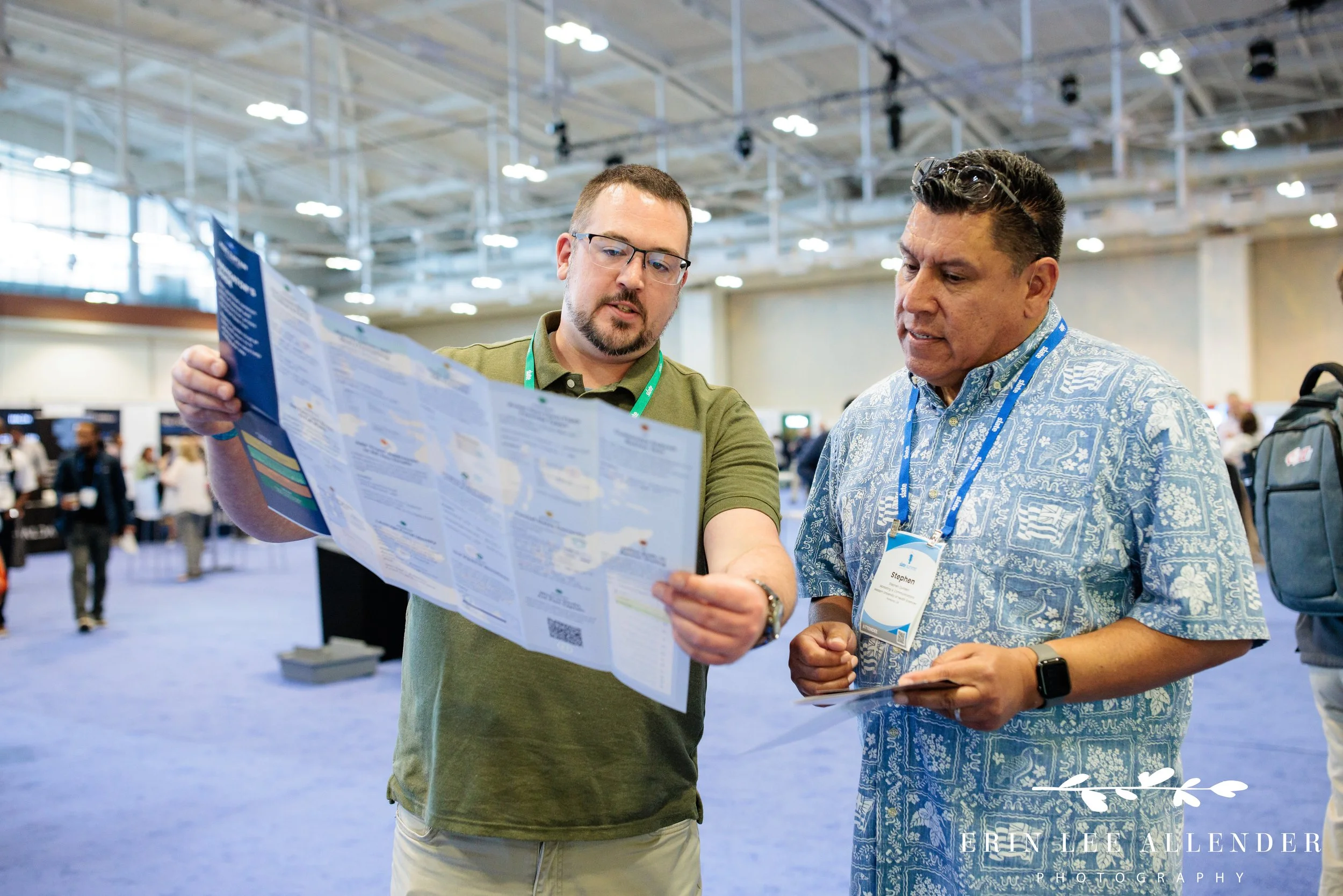 Nashville conference photography — a second Post Captain consultant displaying the Slate cheat-sheet map giveaway at Music City Center