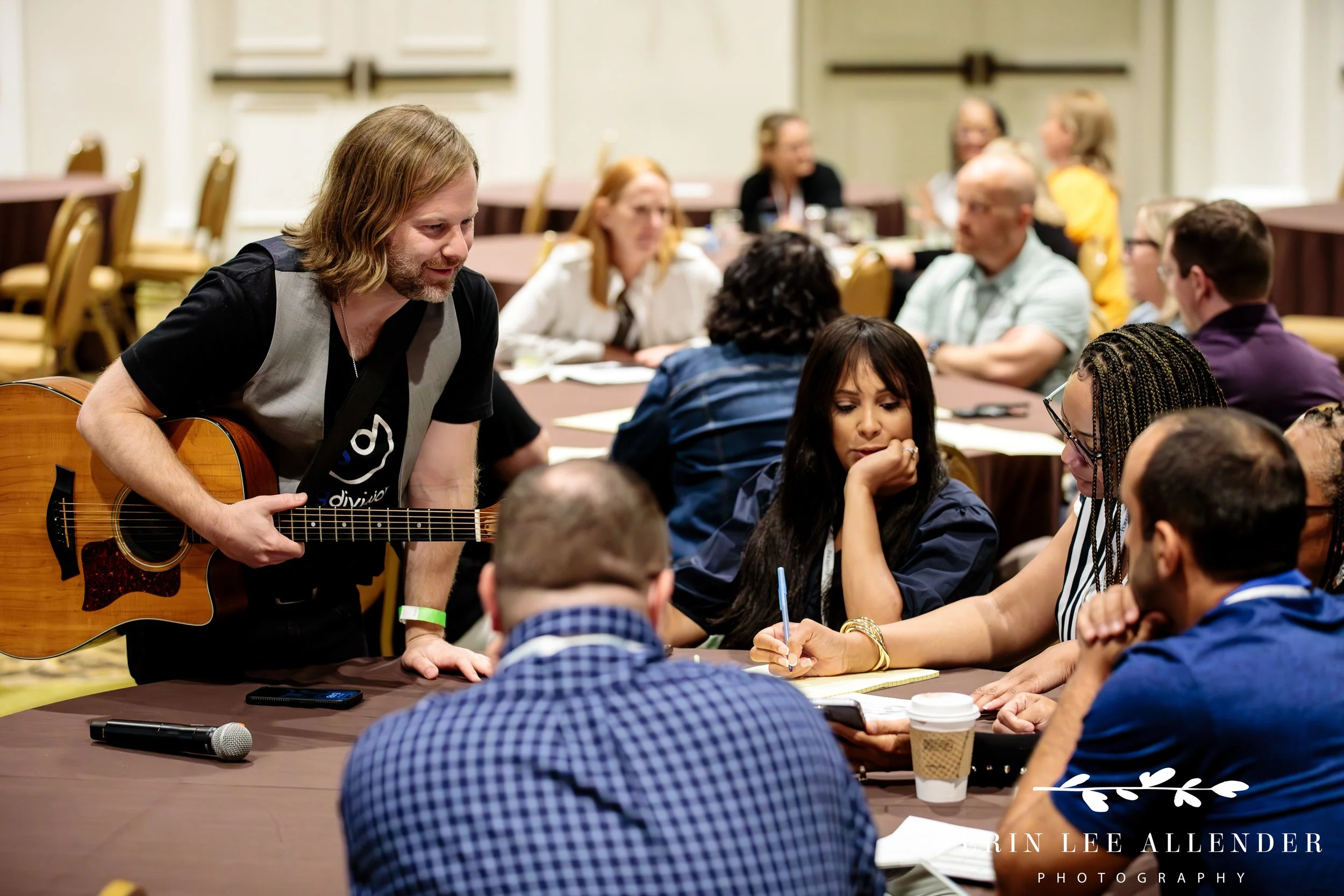 Nashville event photography — conference attendees engaged in conversation at tables during a Forrester CX Conference breakout session at Gaylord Opryland Hotel