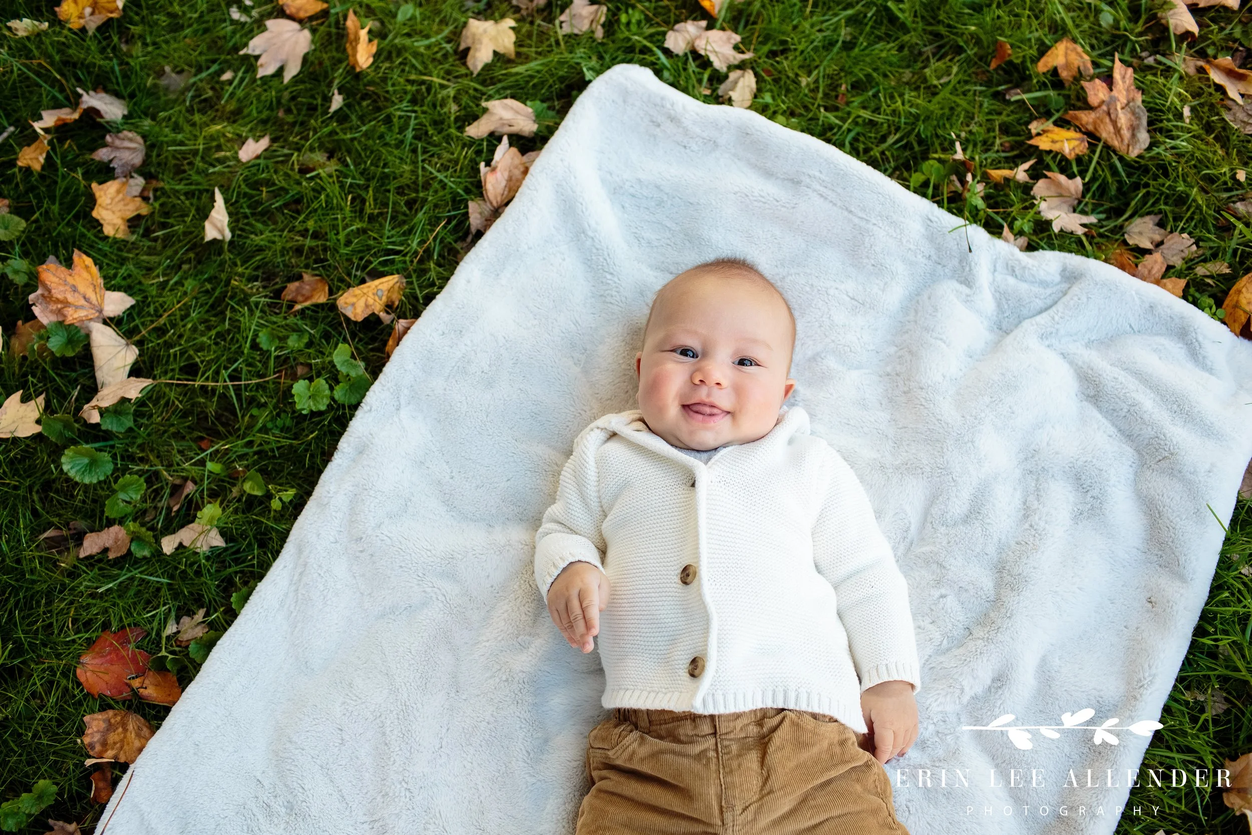 Close-up of baby smiling while held by parents during a Vanderbilt family session.