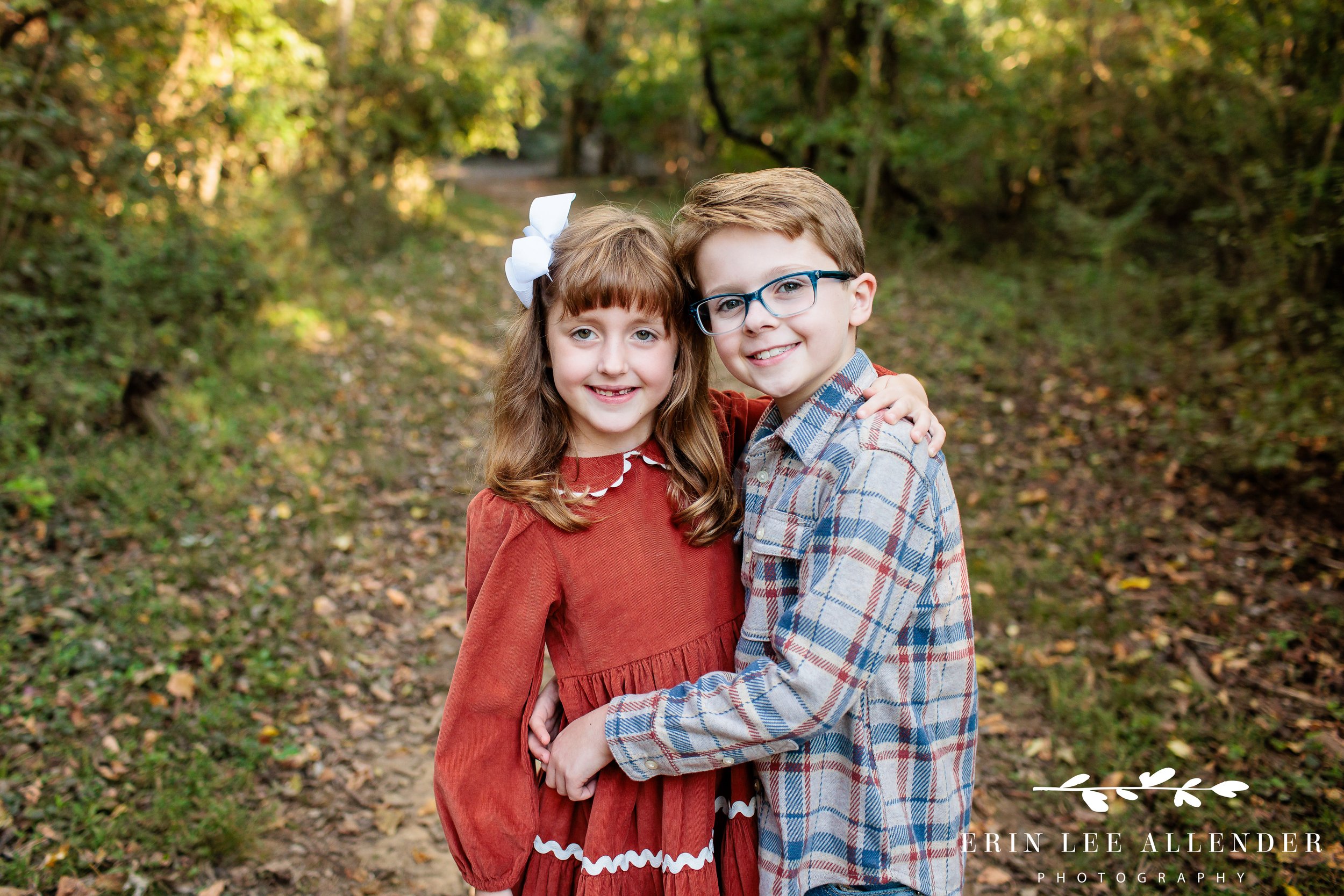 Nashville fall family session — older brother with his arm around his little sister in the woods at Walton Ferry Arboretum