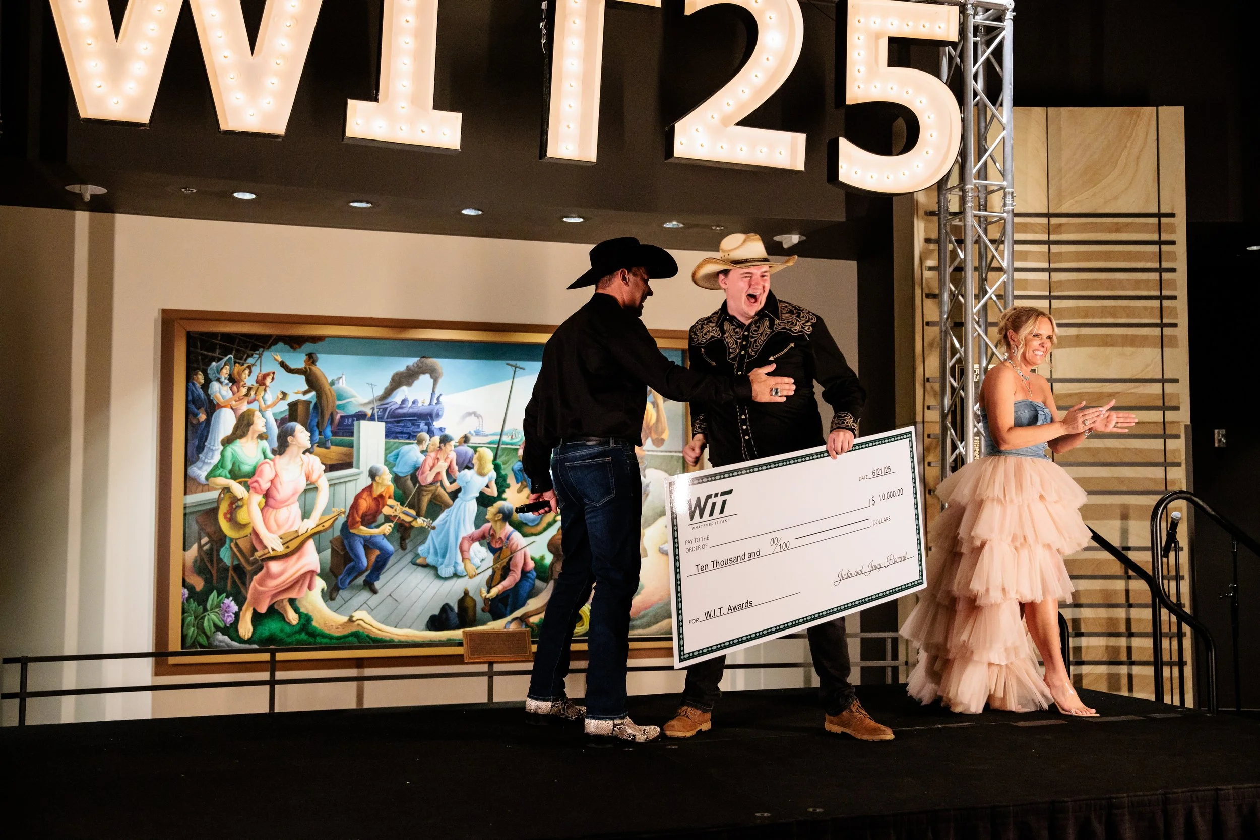 award winner cheers after receiving giant check at country music hall of fame