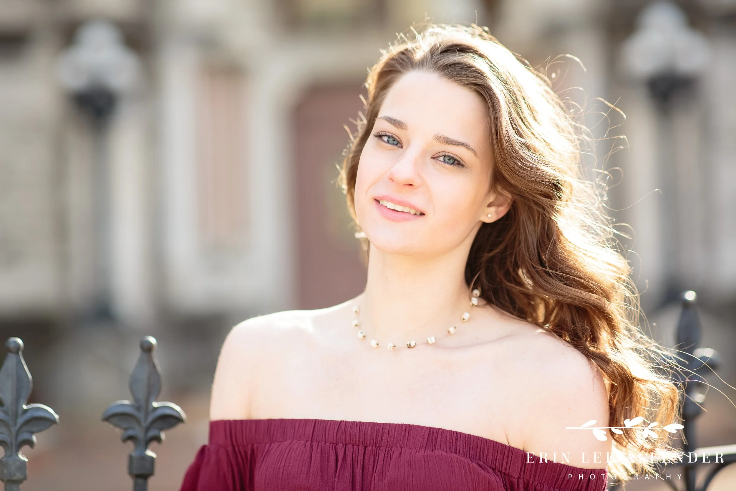 Nashville senior session — senior in burgundy dress at golden hour, downtown Nashville sunset in the background