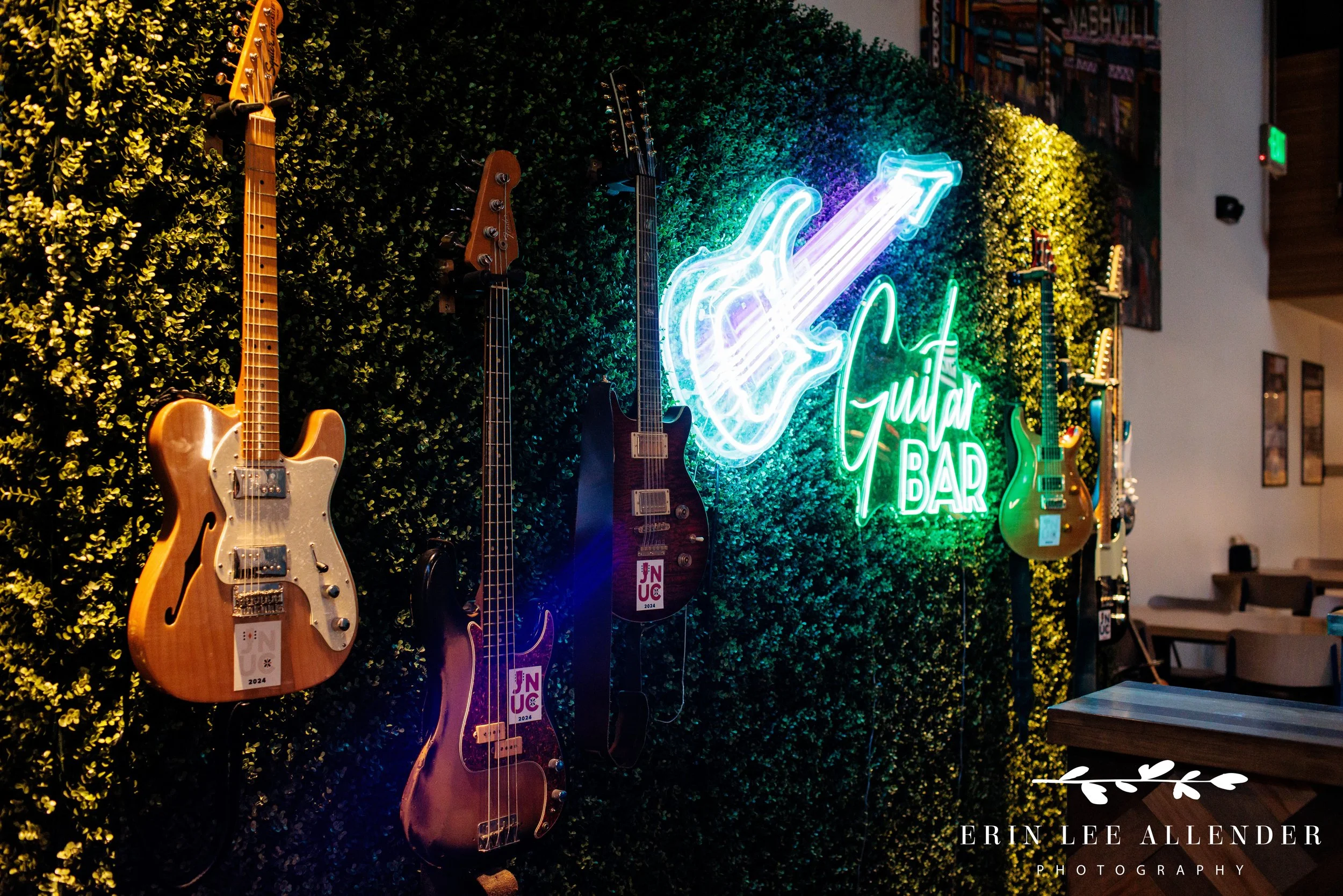 Guests choosing guitars and listening through headphones at the Assembly Food Hall guitar bar during a corporate event