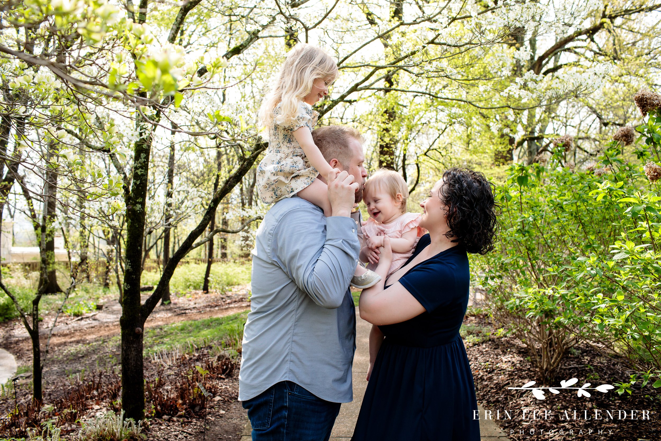 Dad kissing toddler on head among spring tulips at Cheekwood Botanical Garden during milestone session, Nashville family photographer