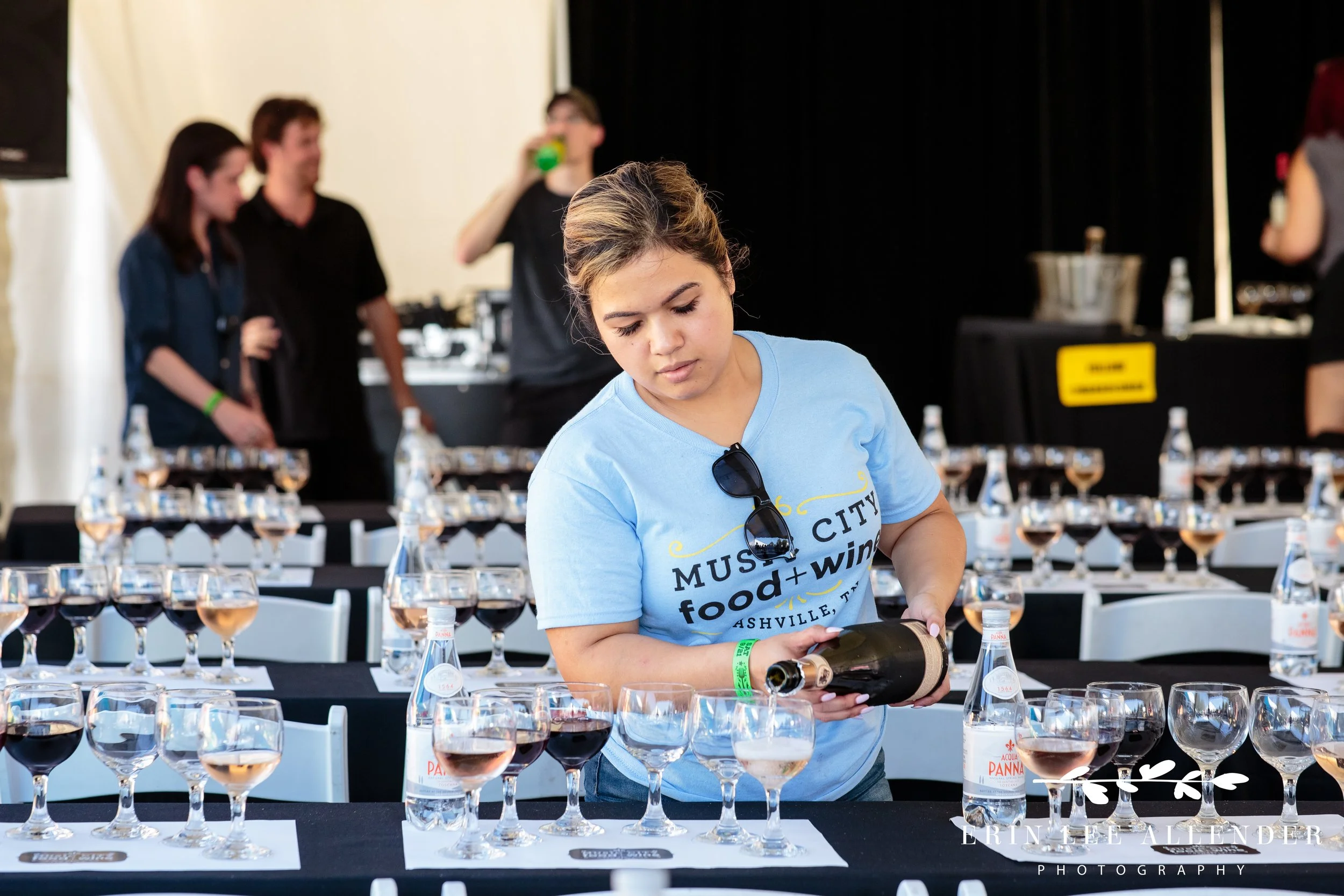 Music City Food and Wine Festival staff member in branded shirt pouring and setting up the tasting event Nashville Tennessee
