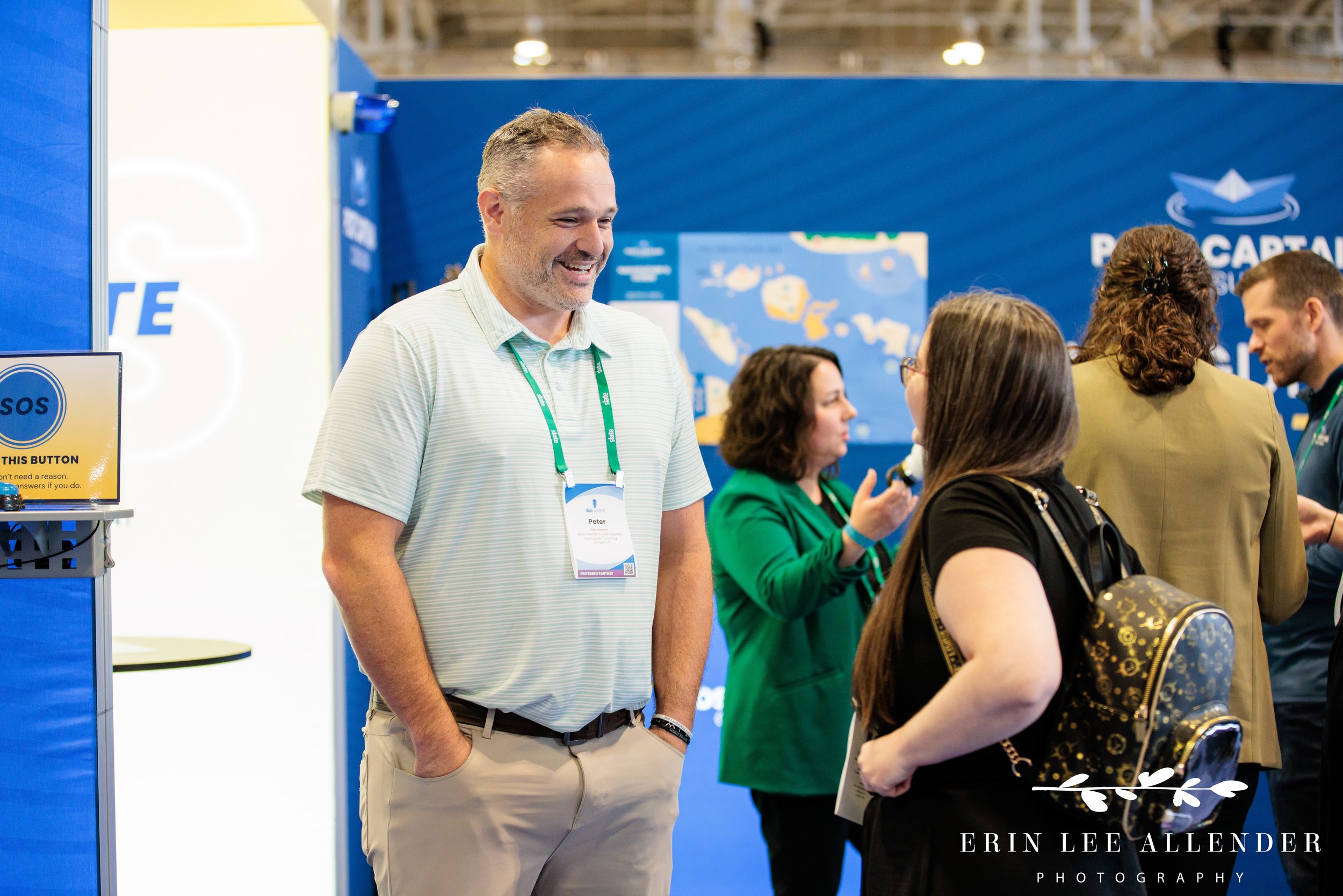 Nashville corporate event photography — Post Captain consultant laughing with a client at their Slate Summit booth, Music City Center