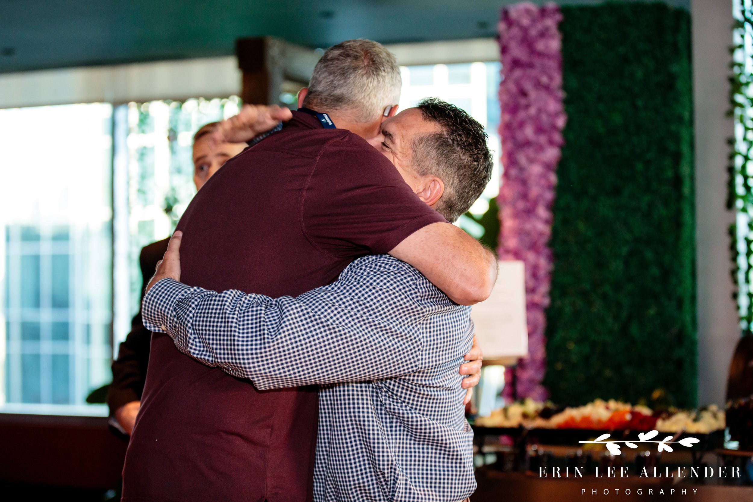 Nashville corporate event photographer — CBIZ Nashville Summit attendees hugging at welcome reception at The Conrad