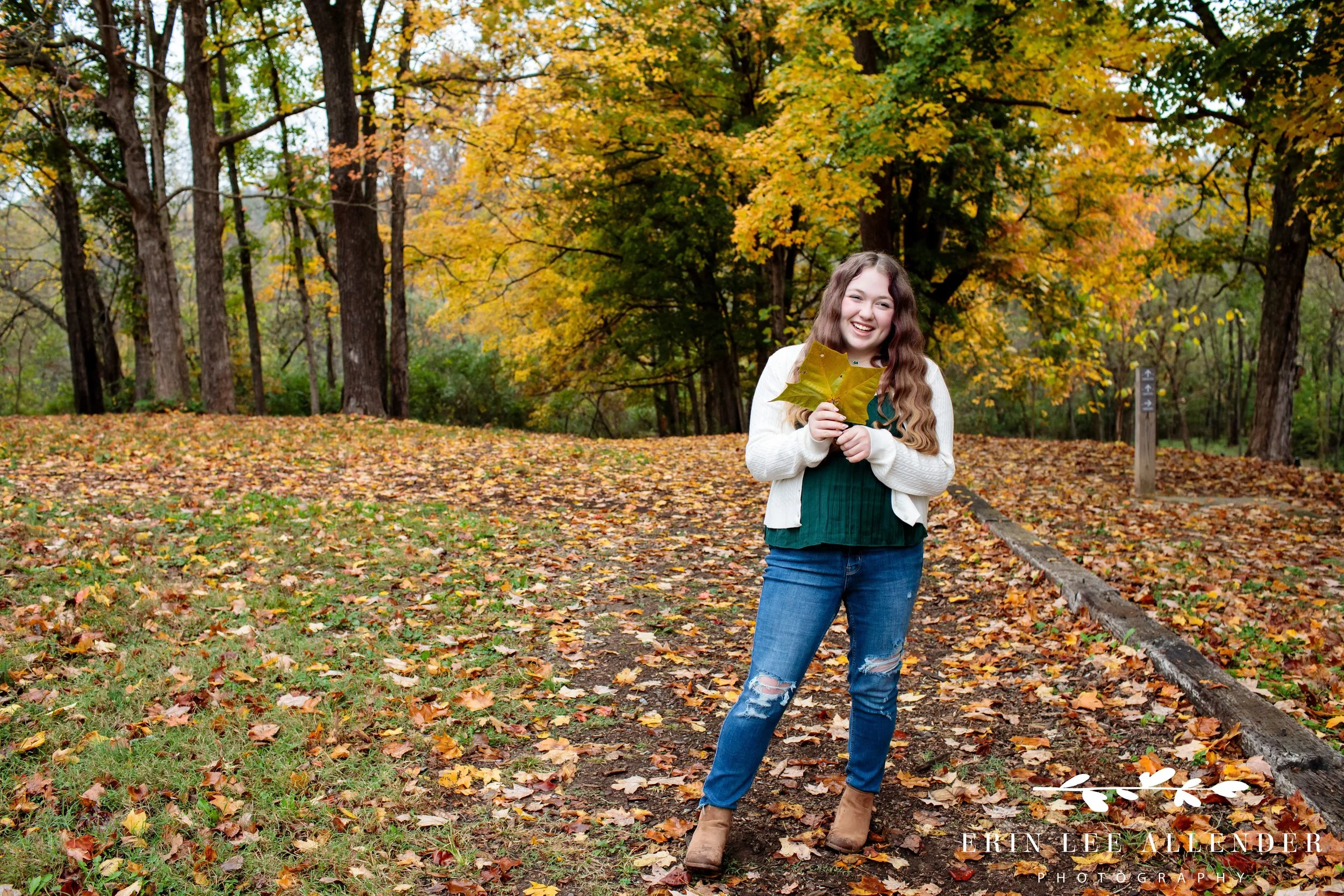 Nashville family photographer captures a young woman holding a fall leaf during a family session at Ellington Agricultural Center