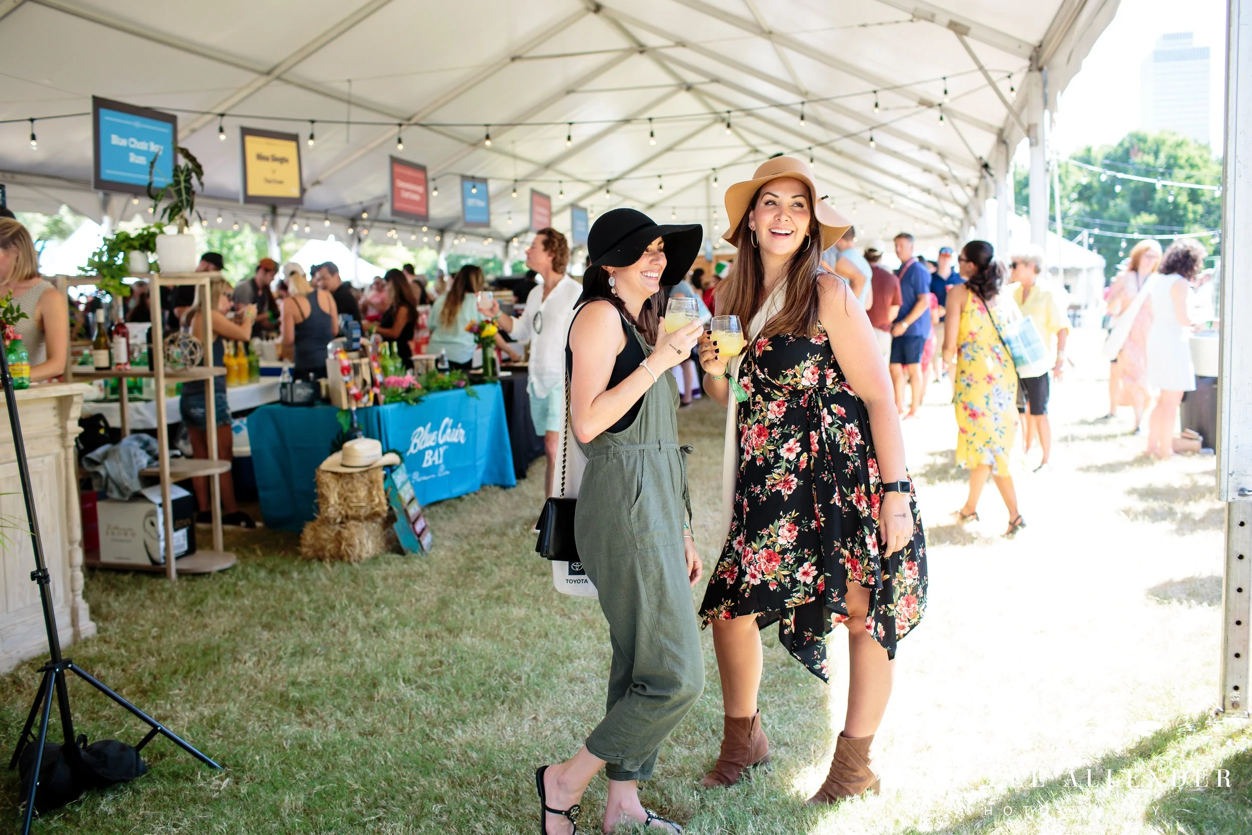 Women in the food tent holding wine glasses and laughing at the Music City Food and Wine Festival Nashville Tennessee