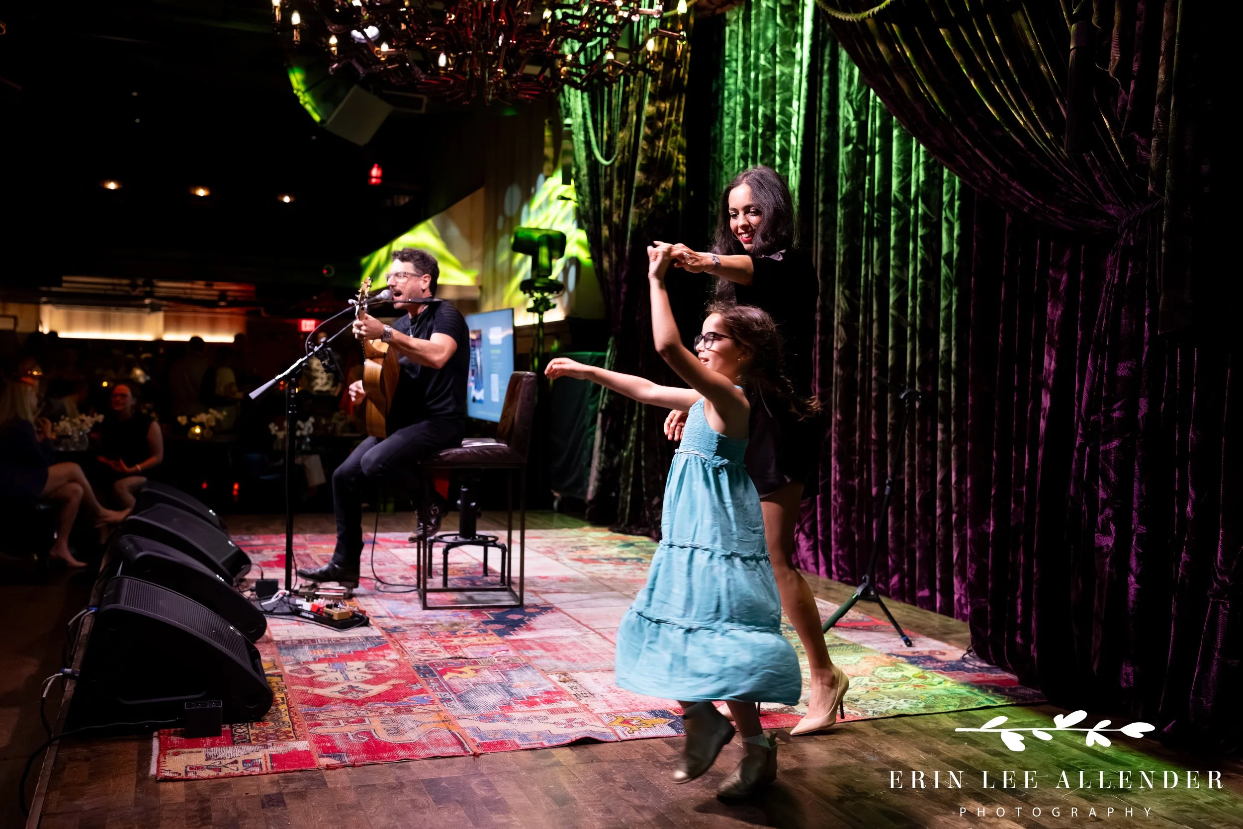 Author twirling her daughter on stage during book release celebration at Hutton Hotel Analog