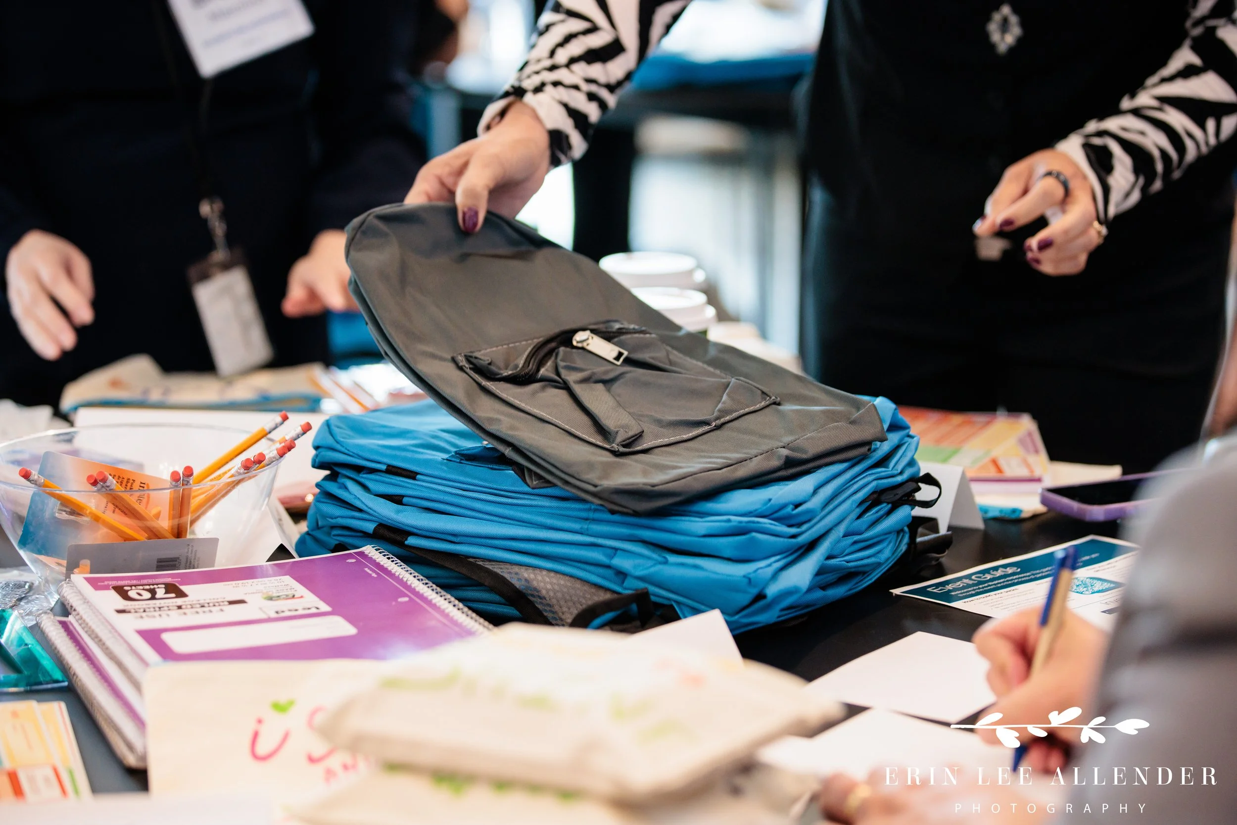 Close-up Nashville corporate event photography of filled backpacks lined up and ready for local students.