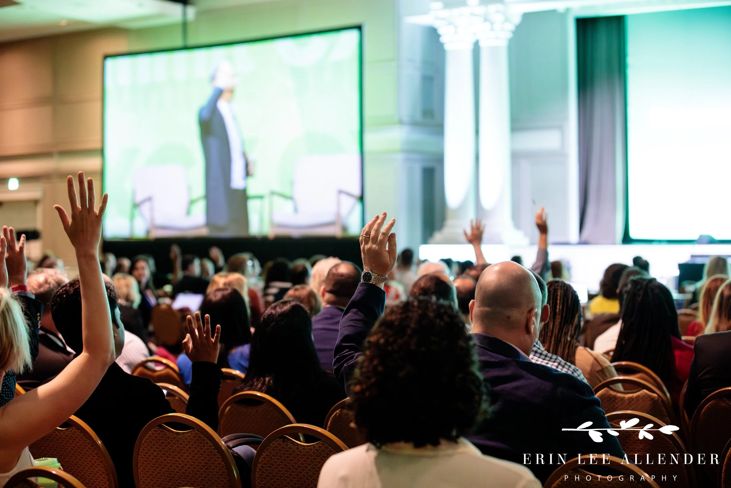 attendees reacting with raised hands during conference discussion at opryland hotel