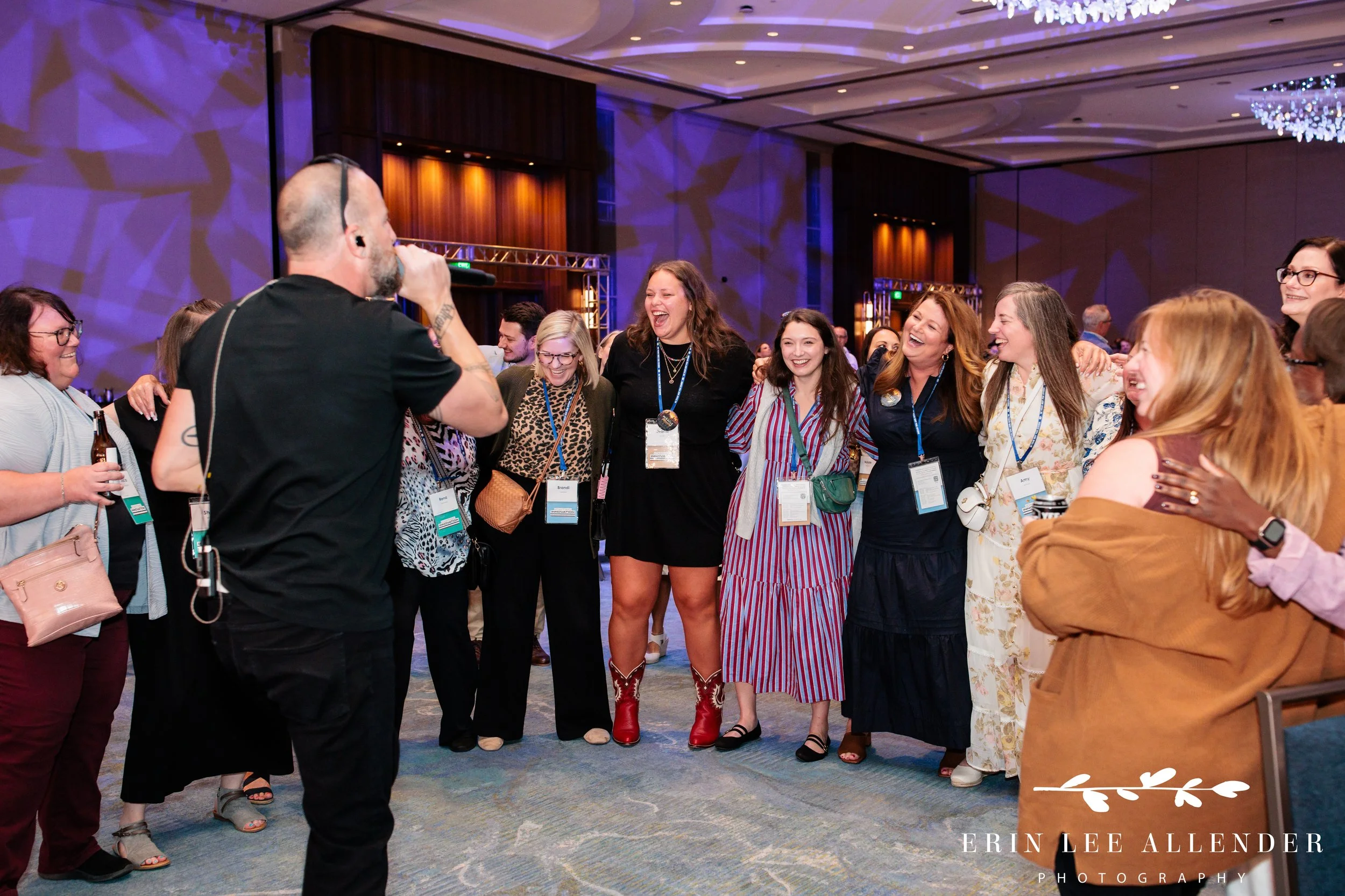 Nashville corporate event photographer capturing guests with arms around each other singing the last song of the night at RubinBrown's awards dinner at Gaylord Opryland Resort