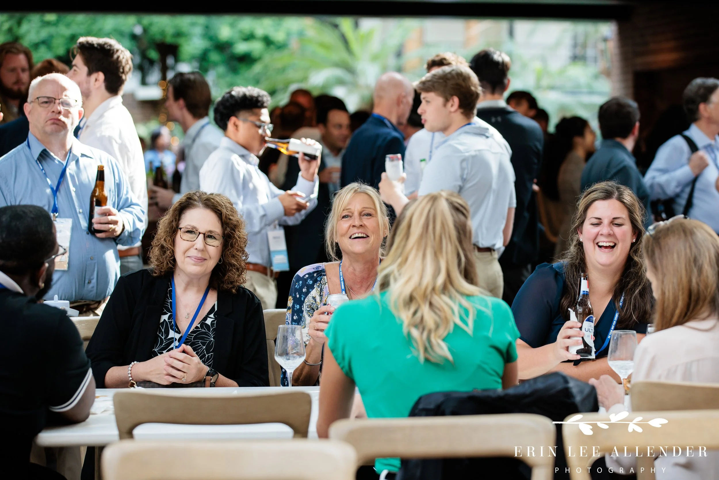 Nashville conference photographer capturing guests laughing together at a table during a RubinBrown conference cocktail reception at Gaylord Opryland Resort