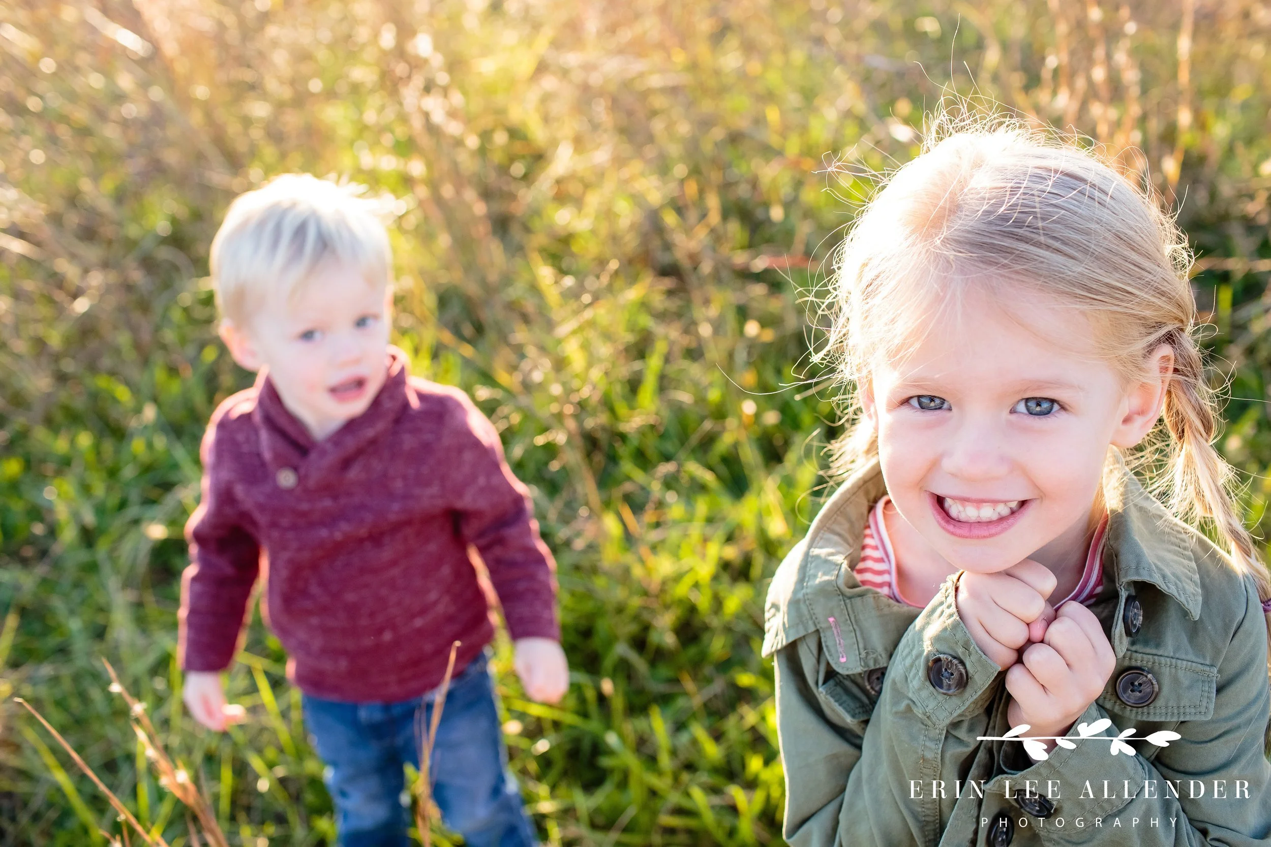 Toddler smiling and playing in the grass during a Gallatin family session at sunset.
