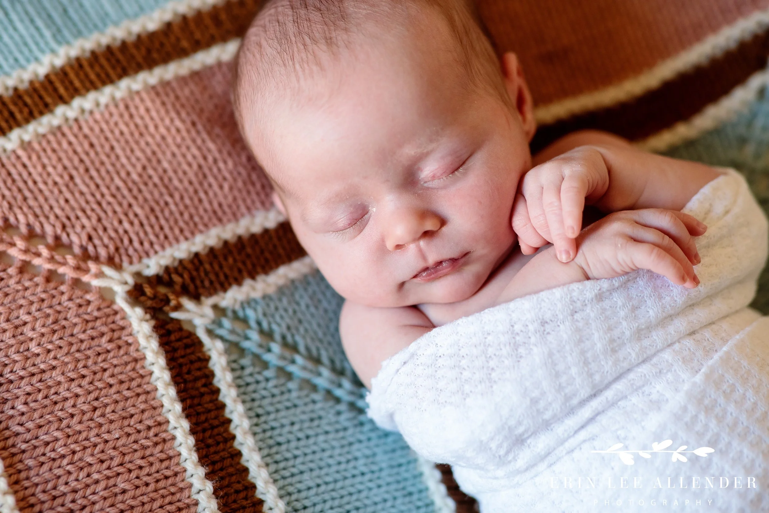 Nashville newborn photographer captures newborn baby swaddled in a white blanket during East Nashville in-home session