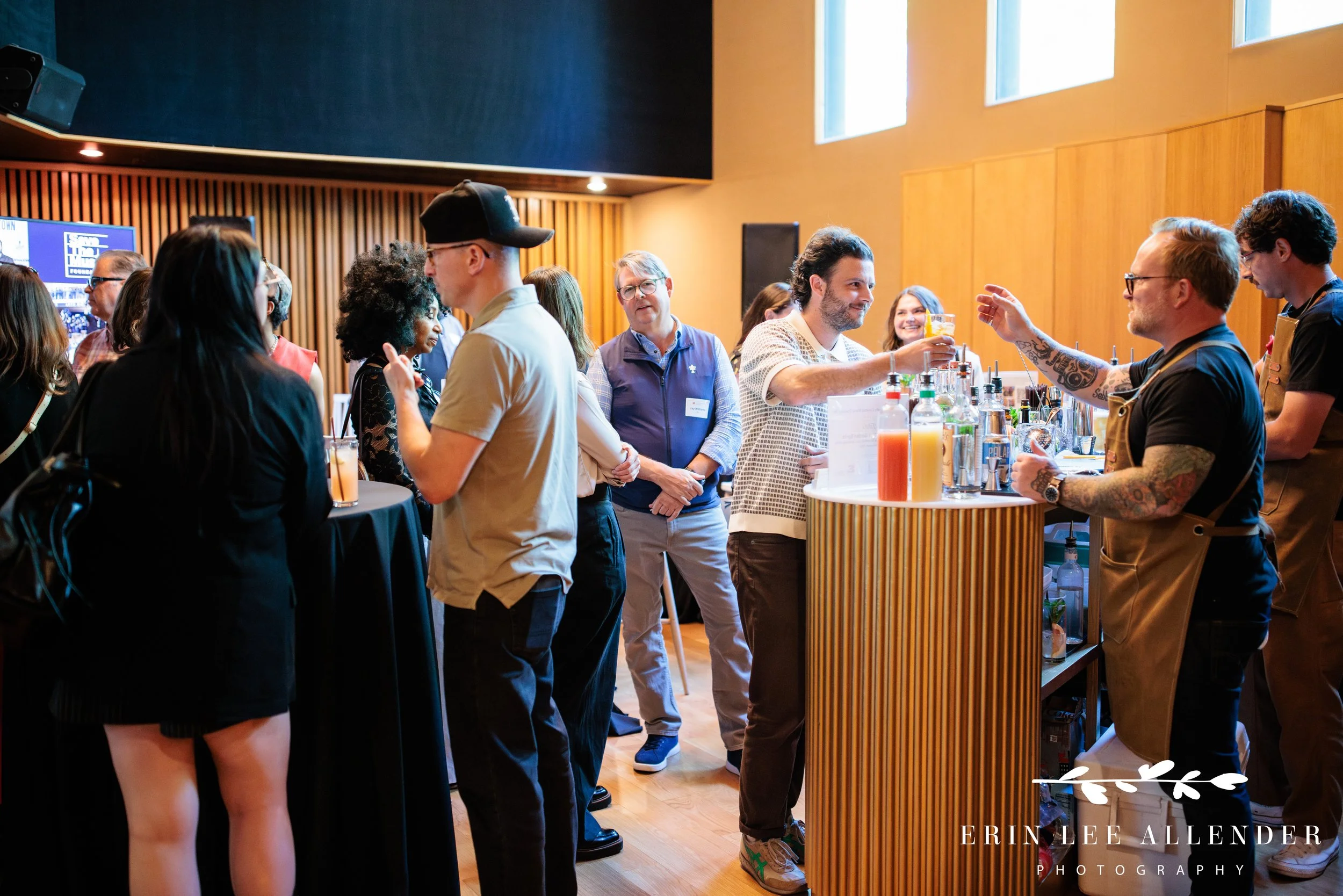 Wide shot of guests networking around a food spread at the Save the Music Foundation fundraiser, Gold Pacific Studios Nashville