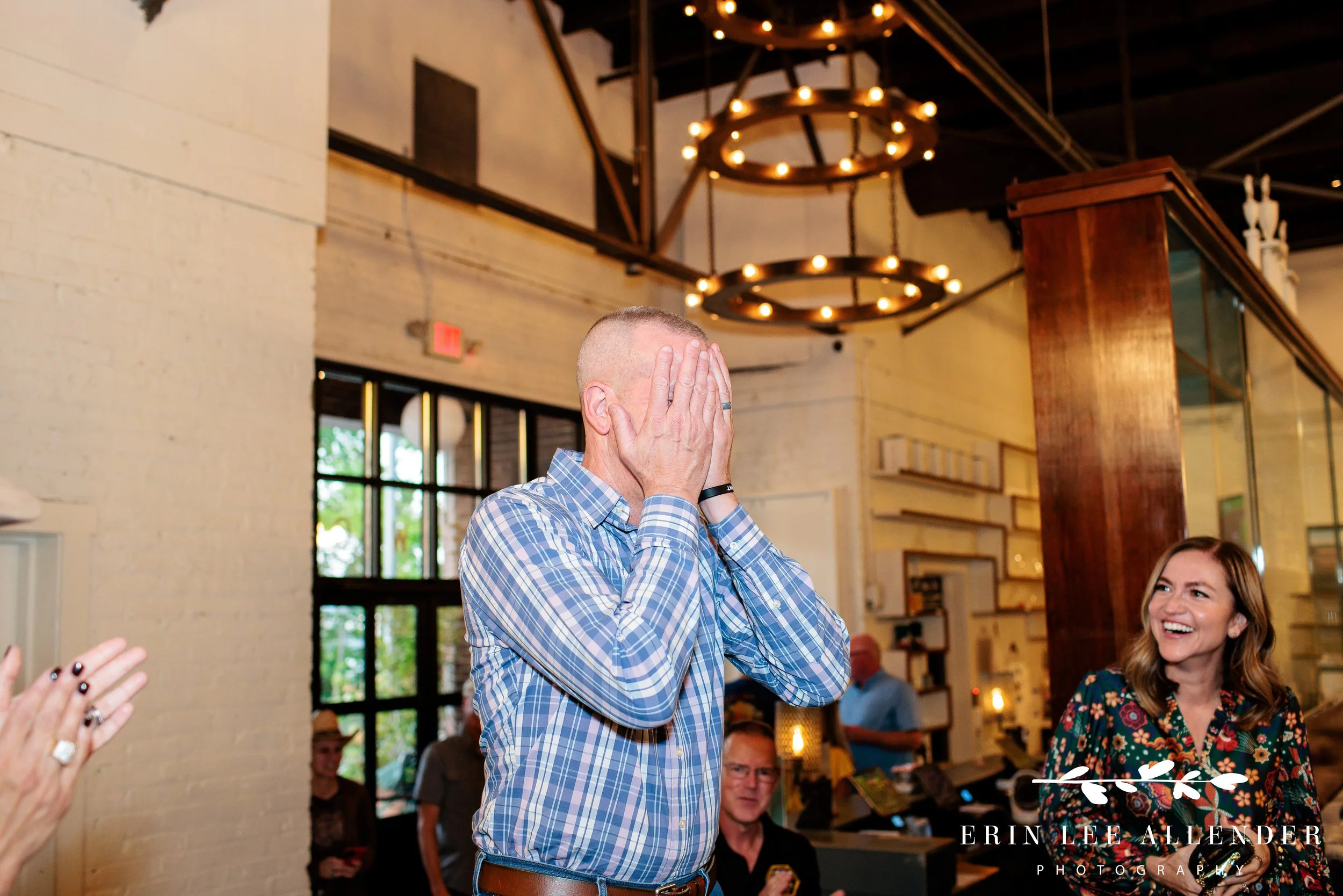 Guest of honor reacting with surprise as attendees cheer