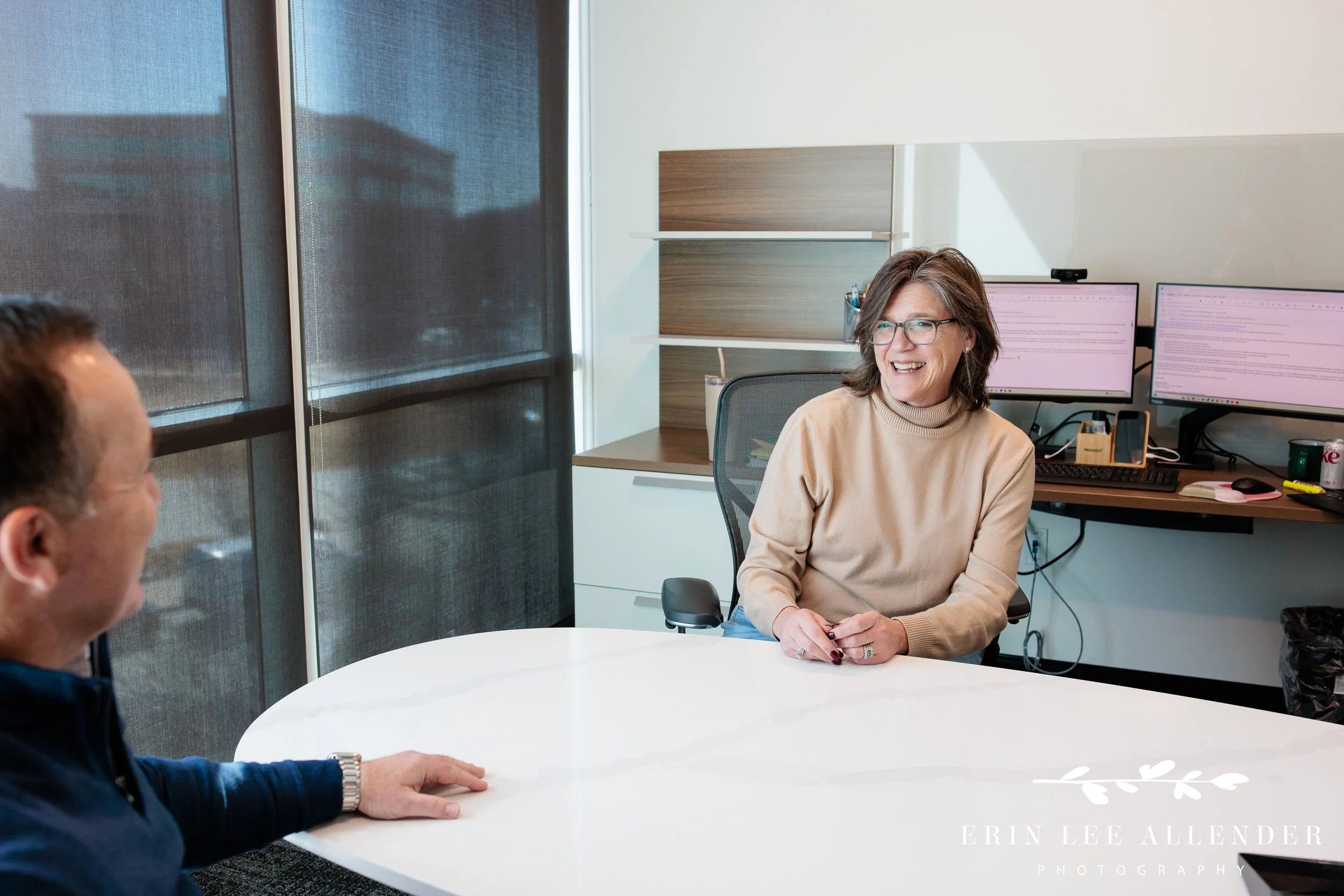 Nashville corporate photography — executive laughing naturally at her desk during candid marketing session at TruGreen
