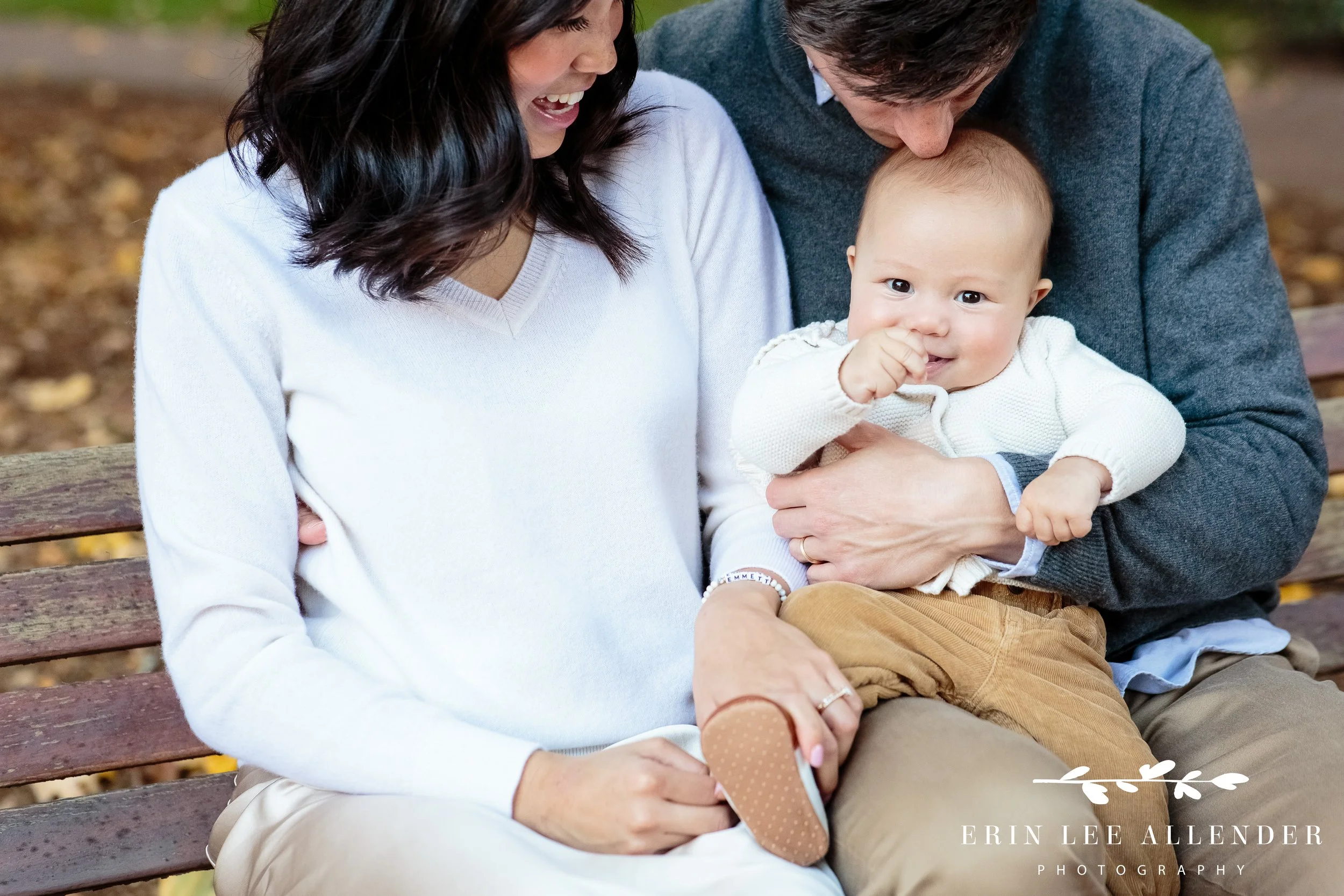 Four-month-old baby held in parents’ arms during a Vanderbilt campus family photography session.