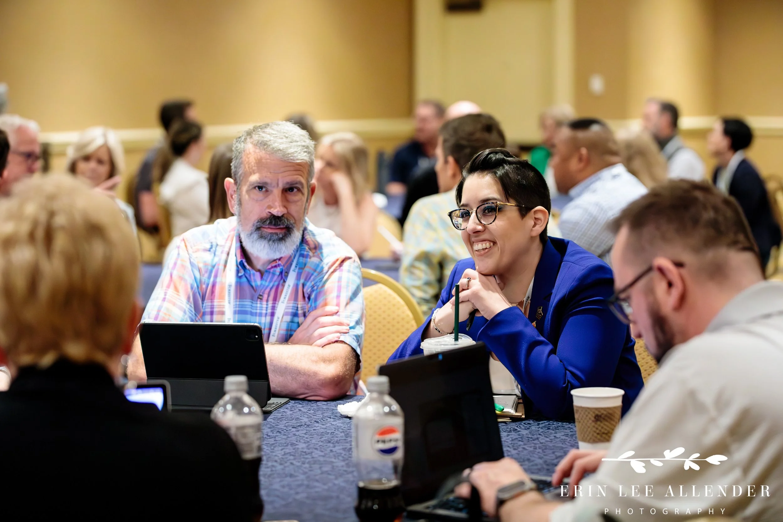 Nashville corporate photography — attendees in conversation at a table during a Forrester CX Conference breakout session, Gaylord Opryland Hotel