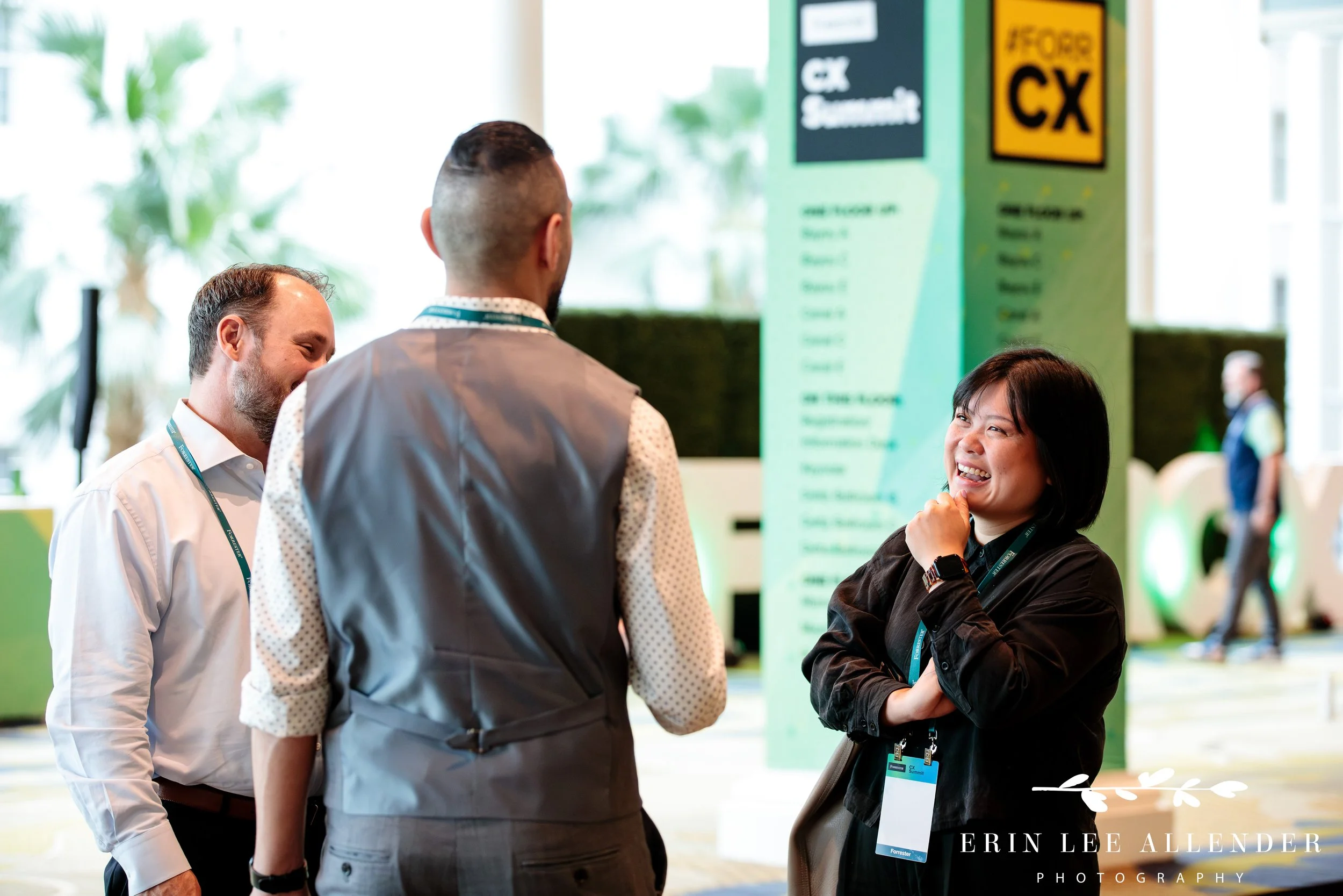 Attendees networking in registration area with signage in the background at corporate CX conference