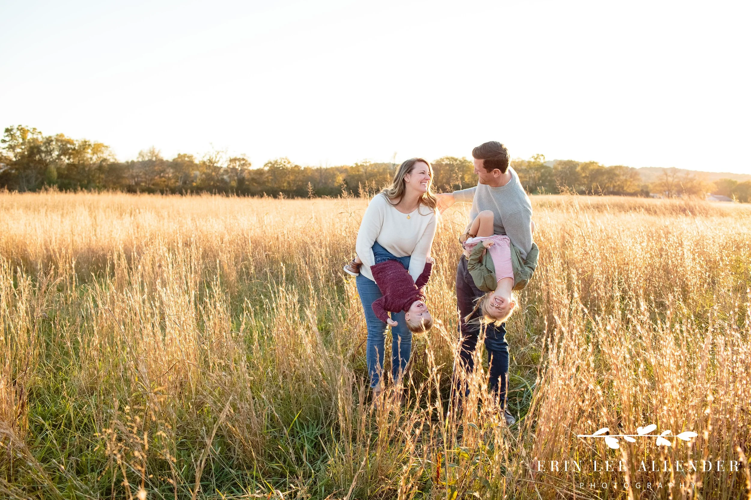Full family scene showing parents and children together in a wide golden field during a Gallatin outdoor session at sunset.