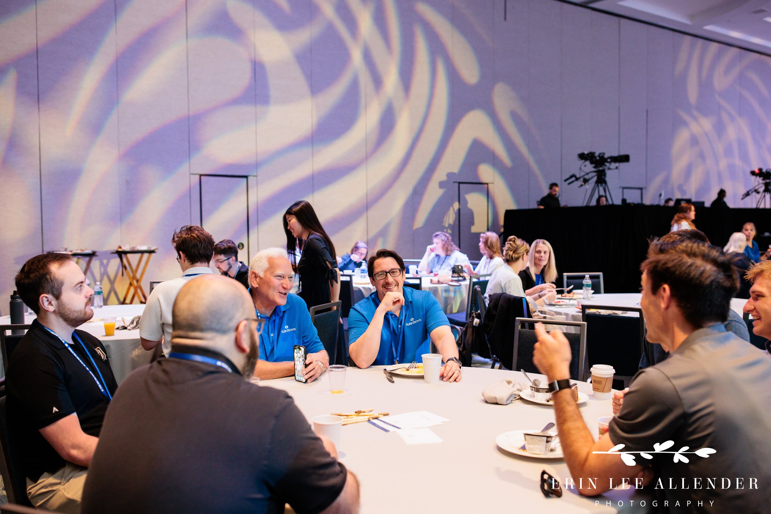 Nashville corporate event photographer capturing attendees laughing together during breakfast at RubinBrown's conference at Gaylord Opryland Resort