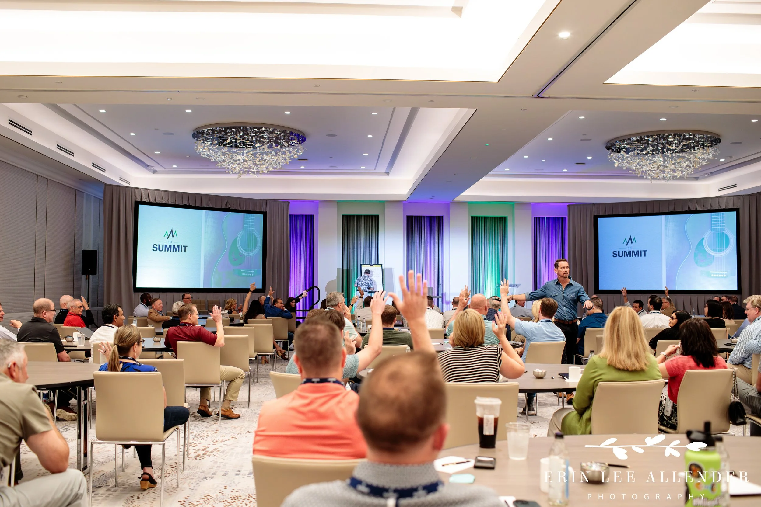 Nashville corporate event photographer — CBIZ Nashville Summit attendees raising hands during Jimmy Yeary's session