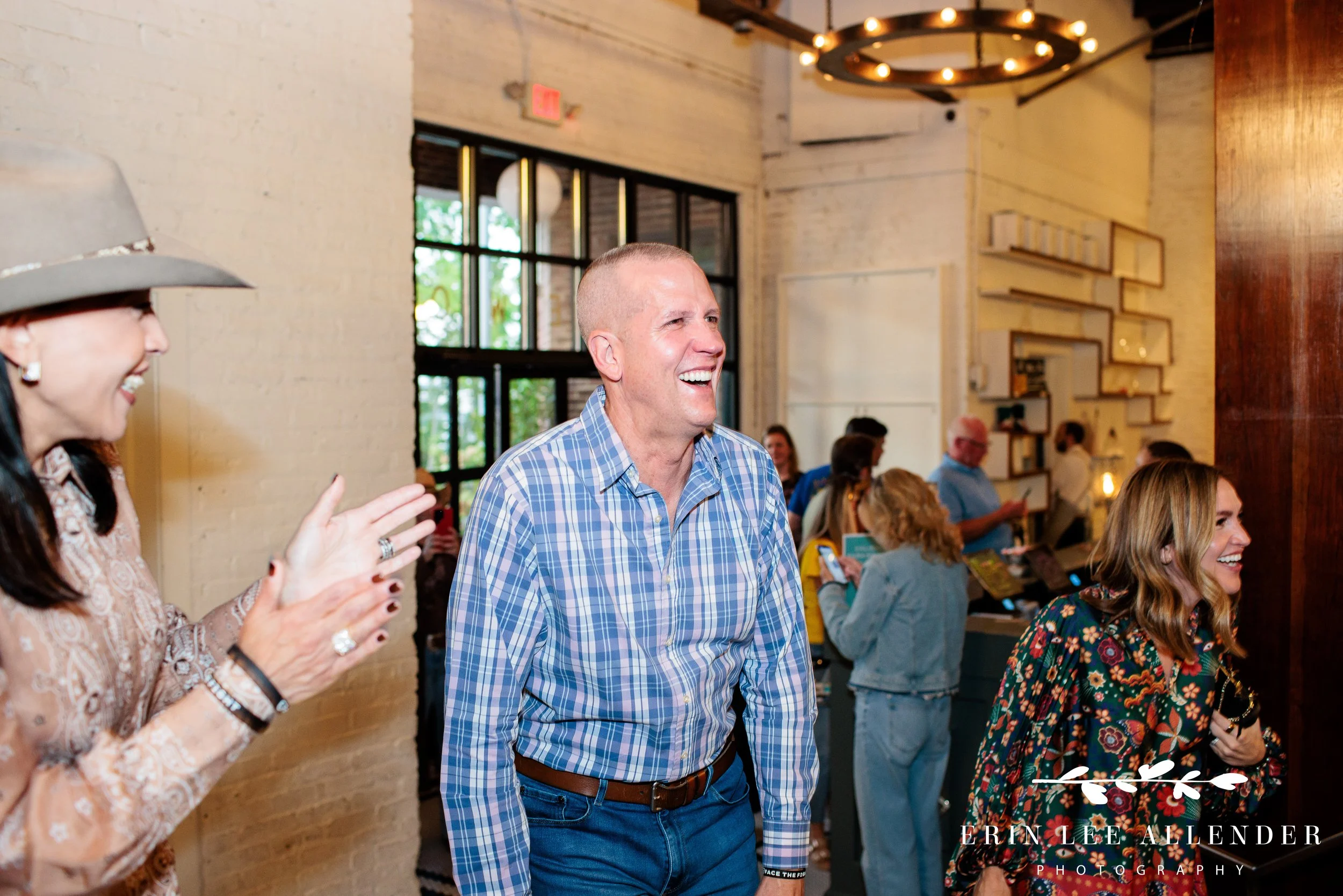 Guest of honor reacting with surprise as attendees cheer