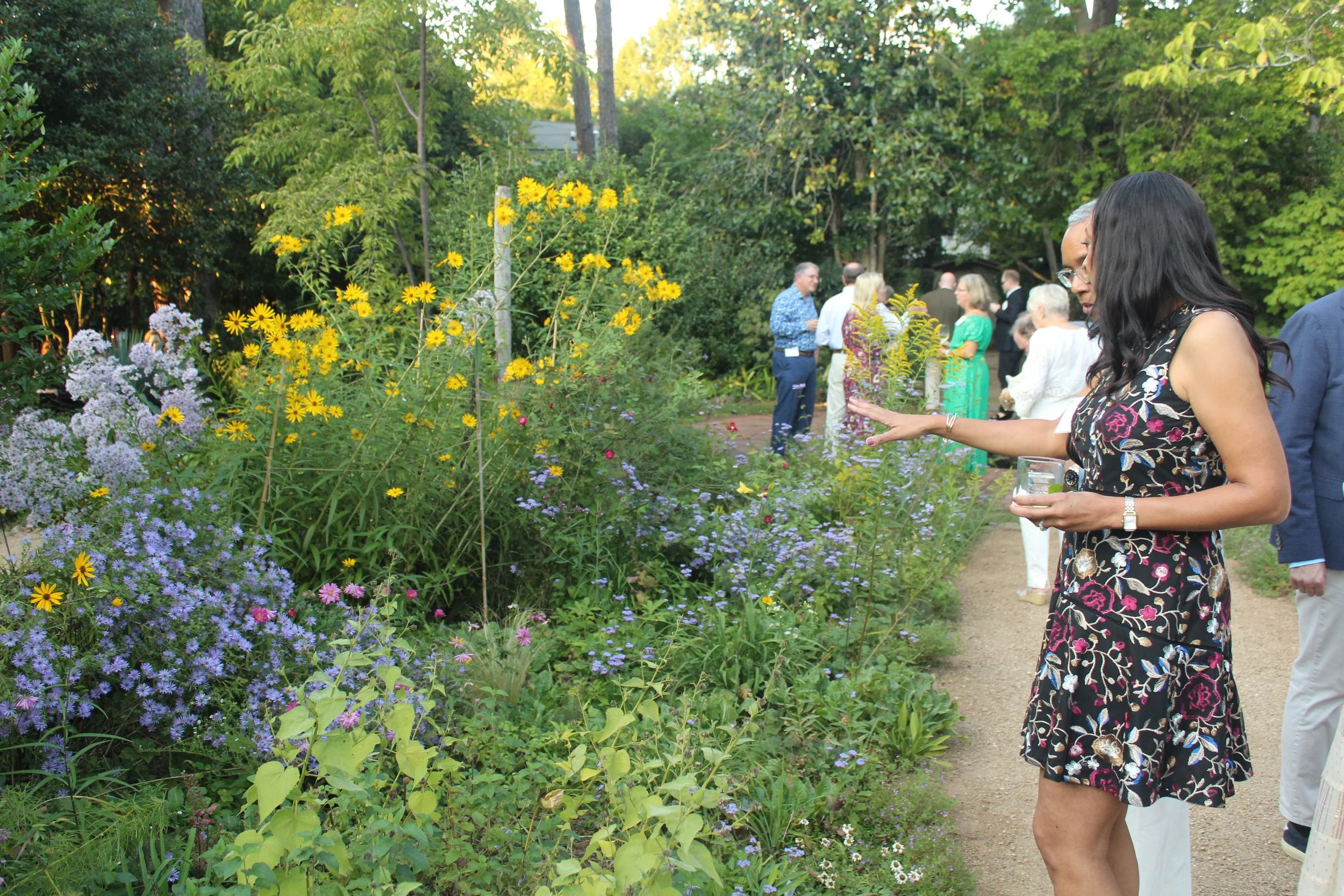 A group standing in a garden pathway with fall blooms surrounding them.