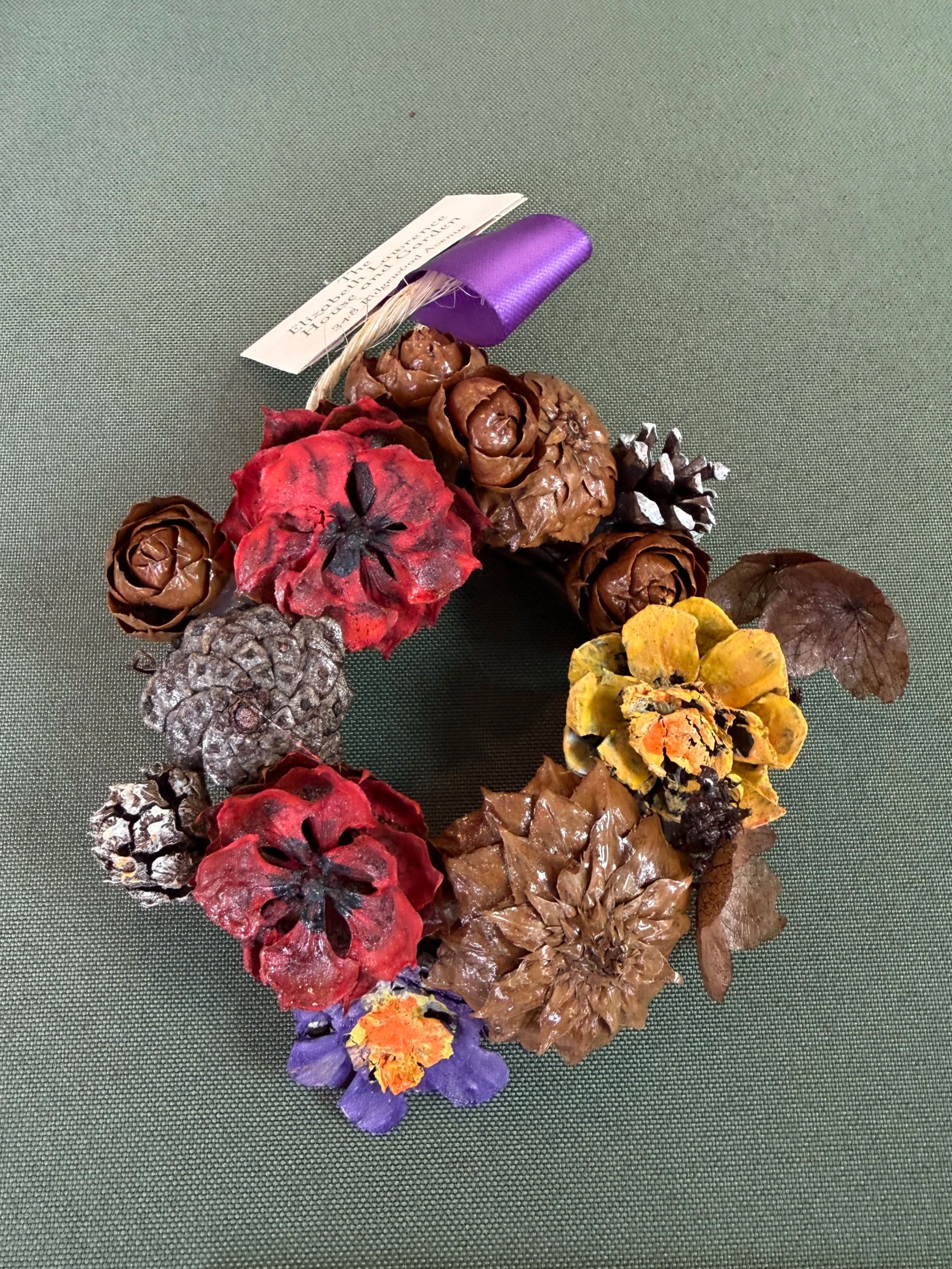 A small wreath made with cones from a variety of trees.