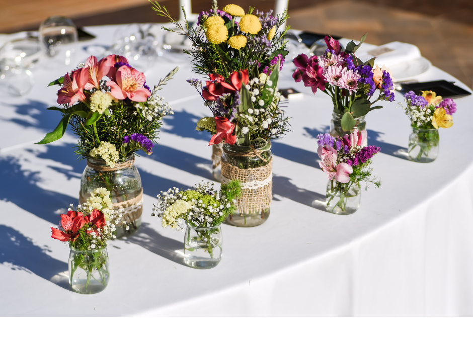 A table full of tussie-mussies in little glass jars