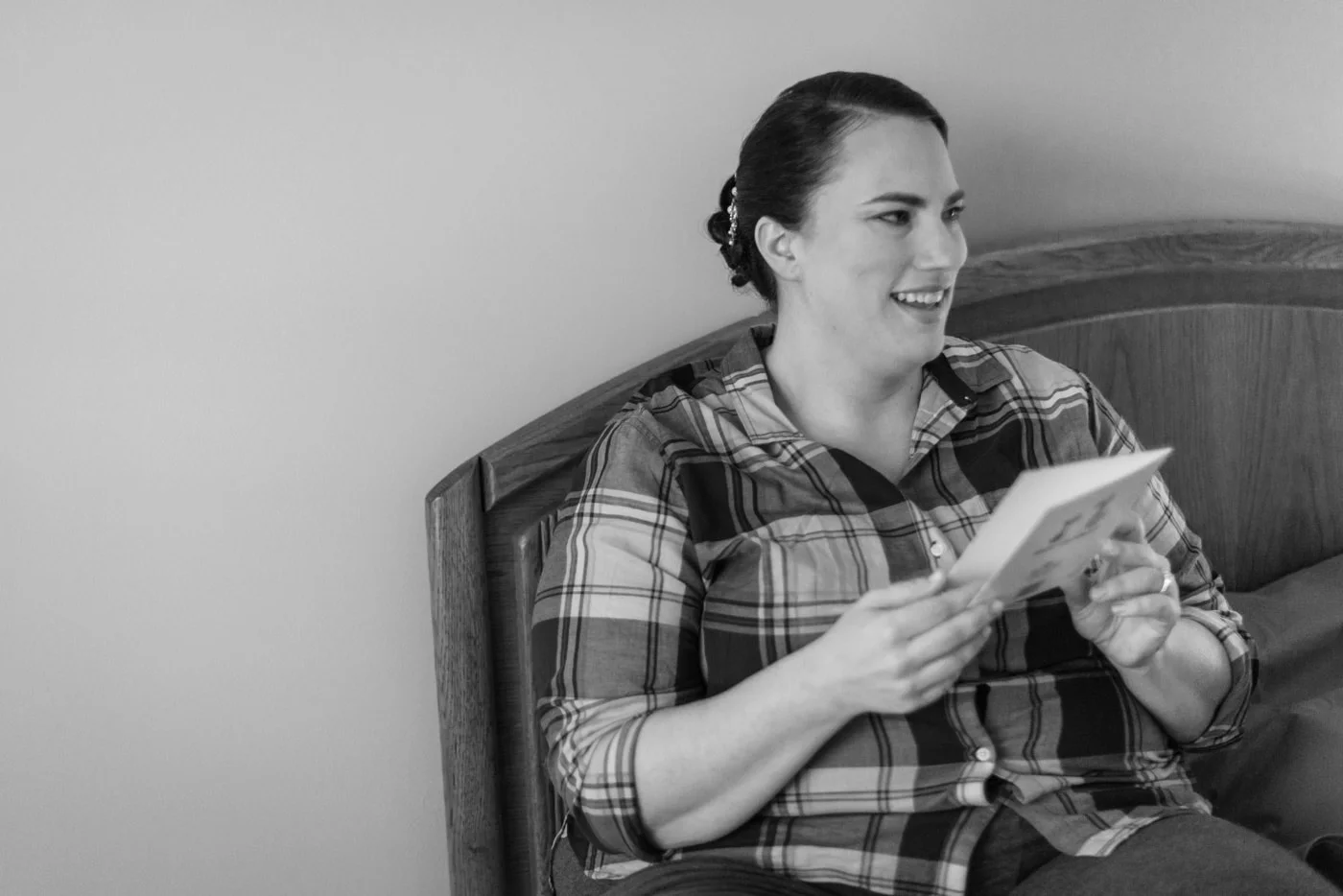Black and white of bride getting ready and readying note from her groom in her home in fairfax, virginia