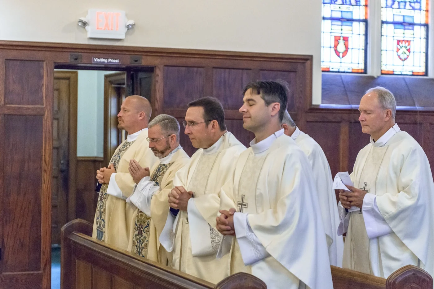 Six priests in the pews during a wedding ceremony at St James Catholic Church in Falls Church, Virginia
