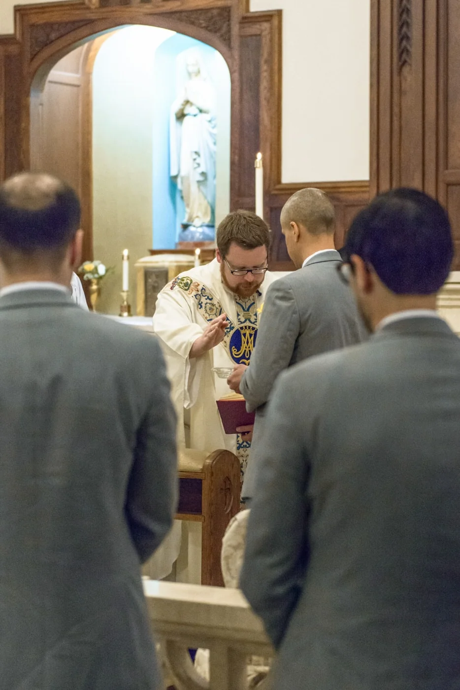 The priest blesses the rings during a wedding ceremony at St James Catholic Church in Falls Church, Virginia