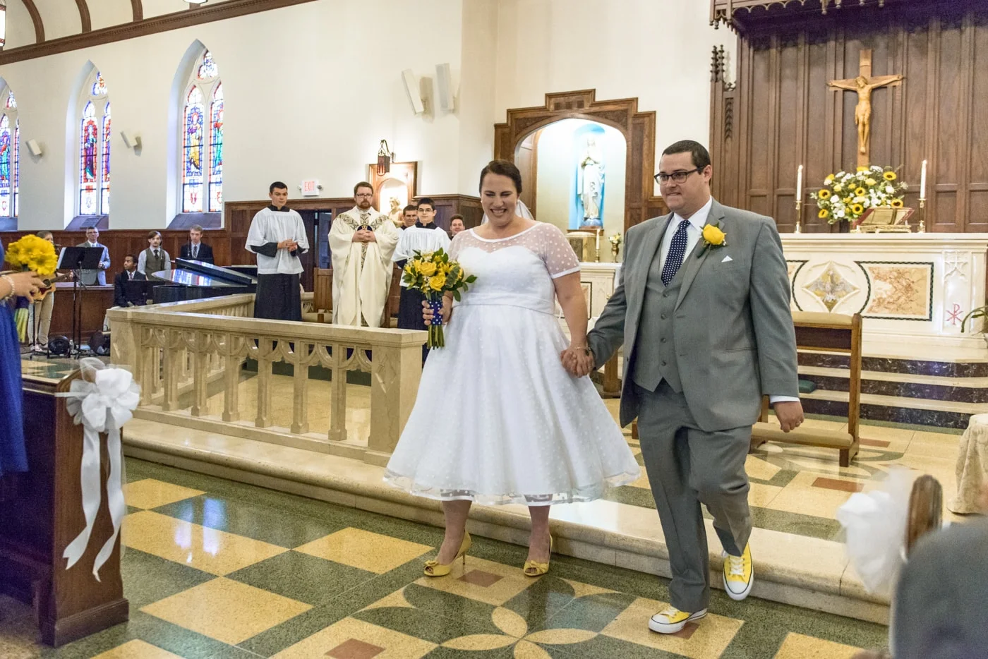 The bride and groom face their guests at the end of their wedding ceremony at St James Catholic Church in Falls Church, Virginia