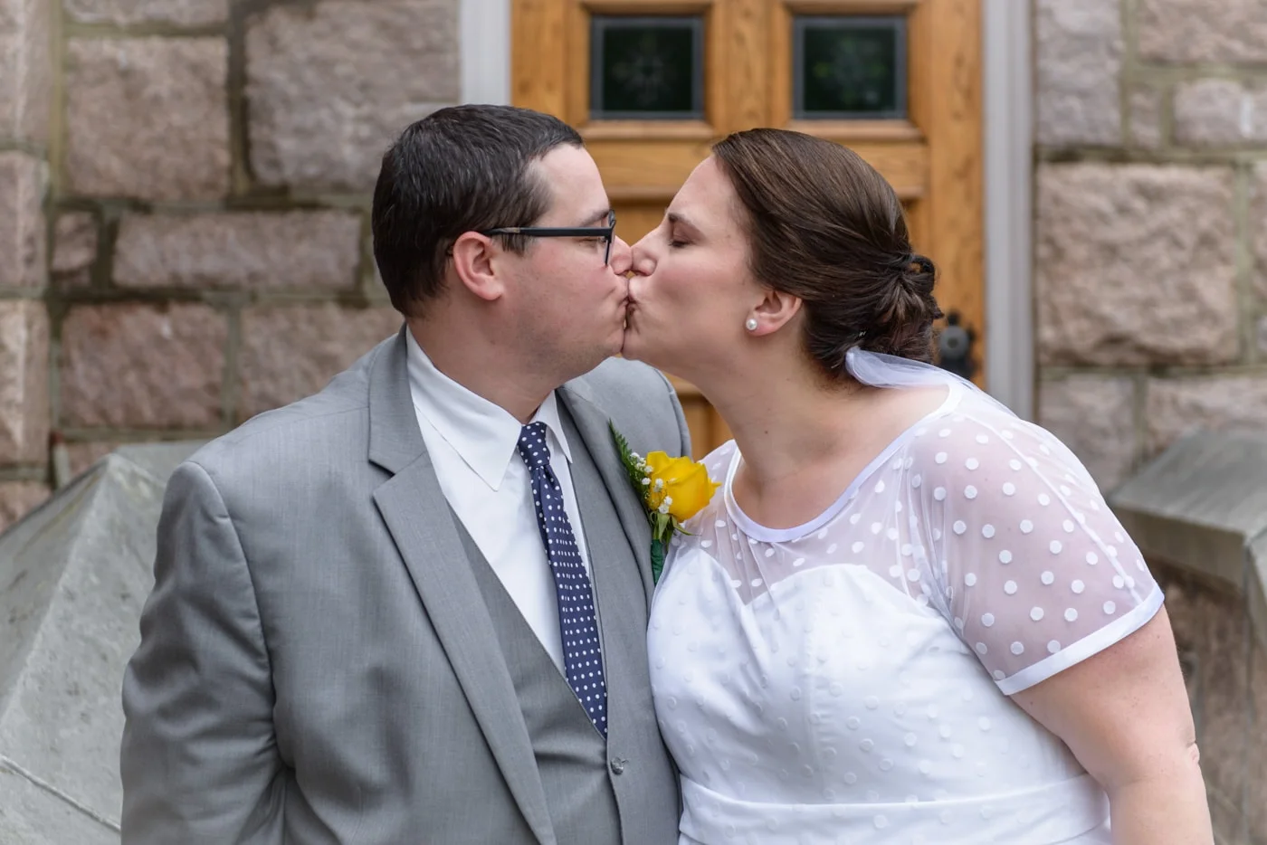 The bride and groom kiss outside St James Catholic Church in Falls Church, Virginia