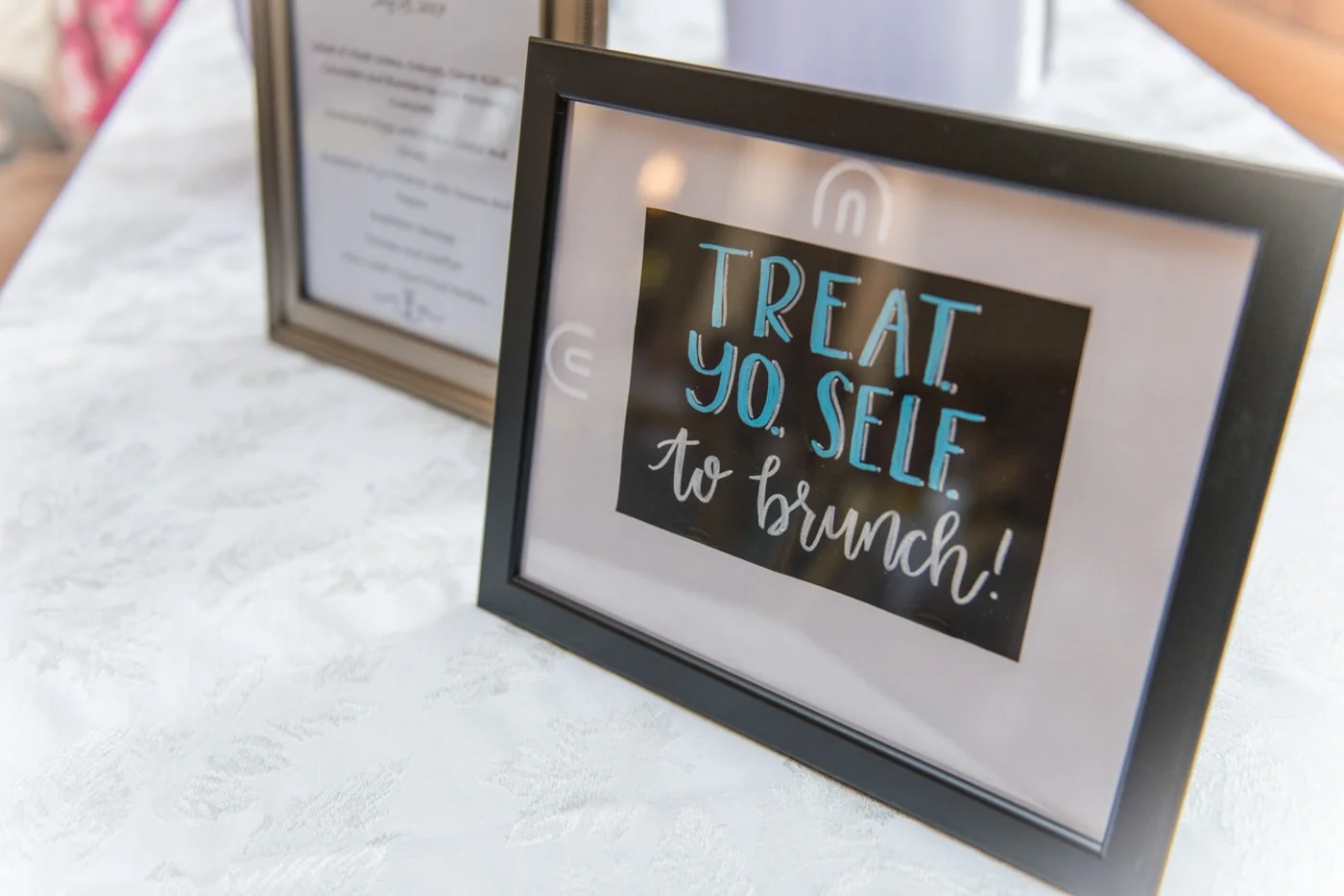 Sign at a brunch wedding that says “Treat Yo Self to brunch!”