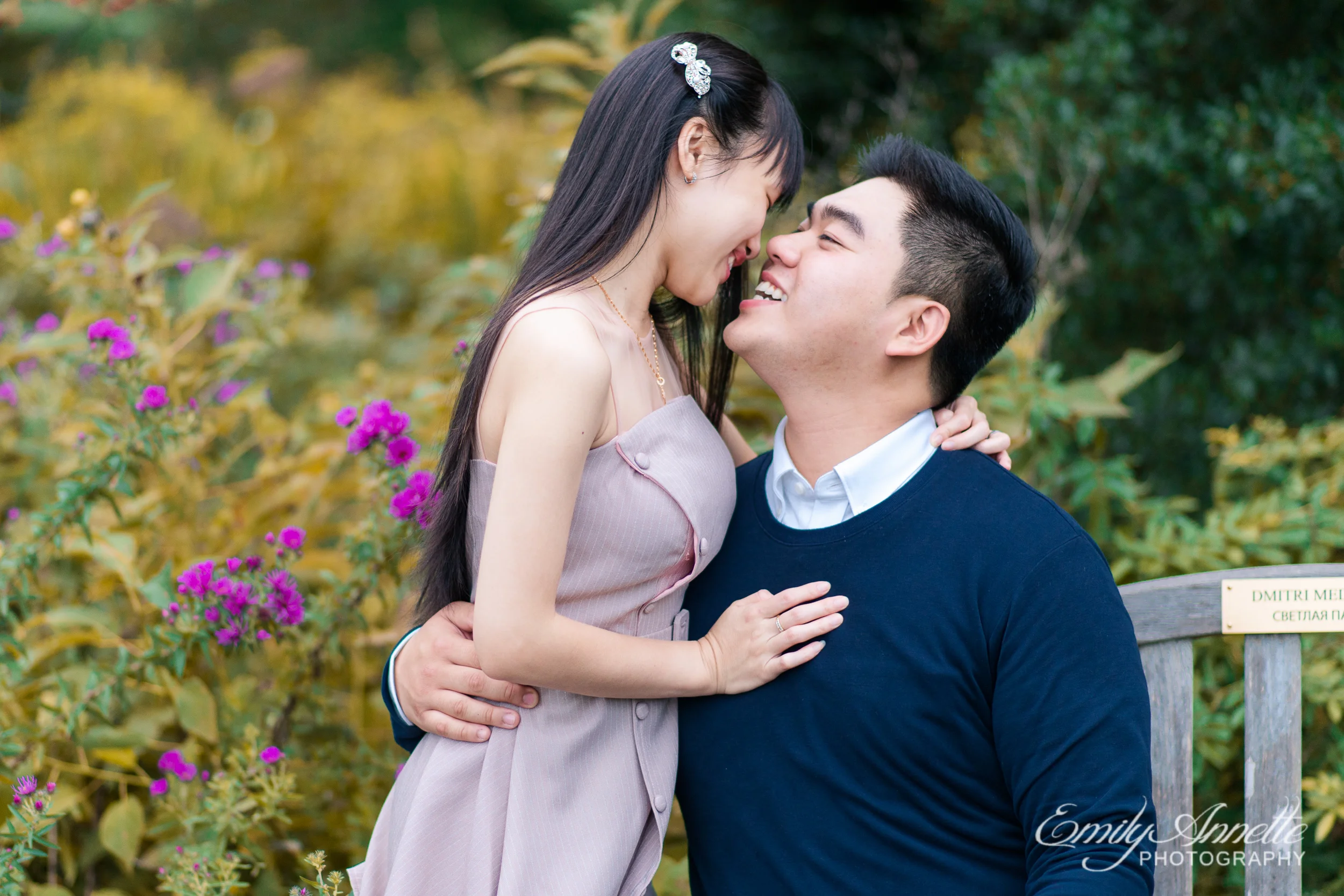 A young couple laugh and embrace in the garden at Green Spring Gardens Park in Fairfax, Virginia