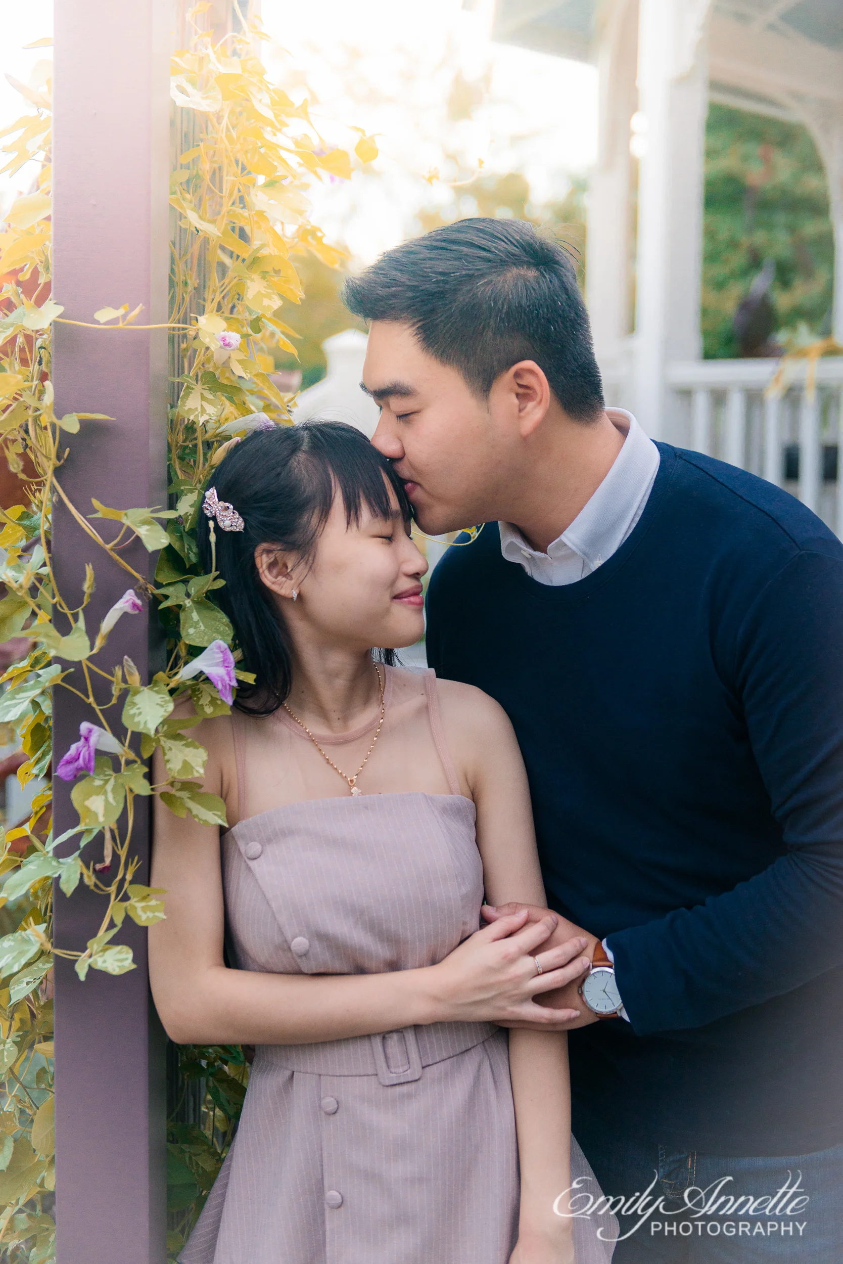 A young man kisses his girlfriend’s forehead as they hold hands in the garden at Green Spring Gardens Park in Fairfax, Virginia