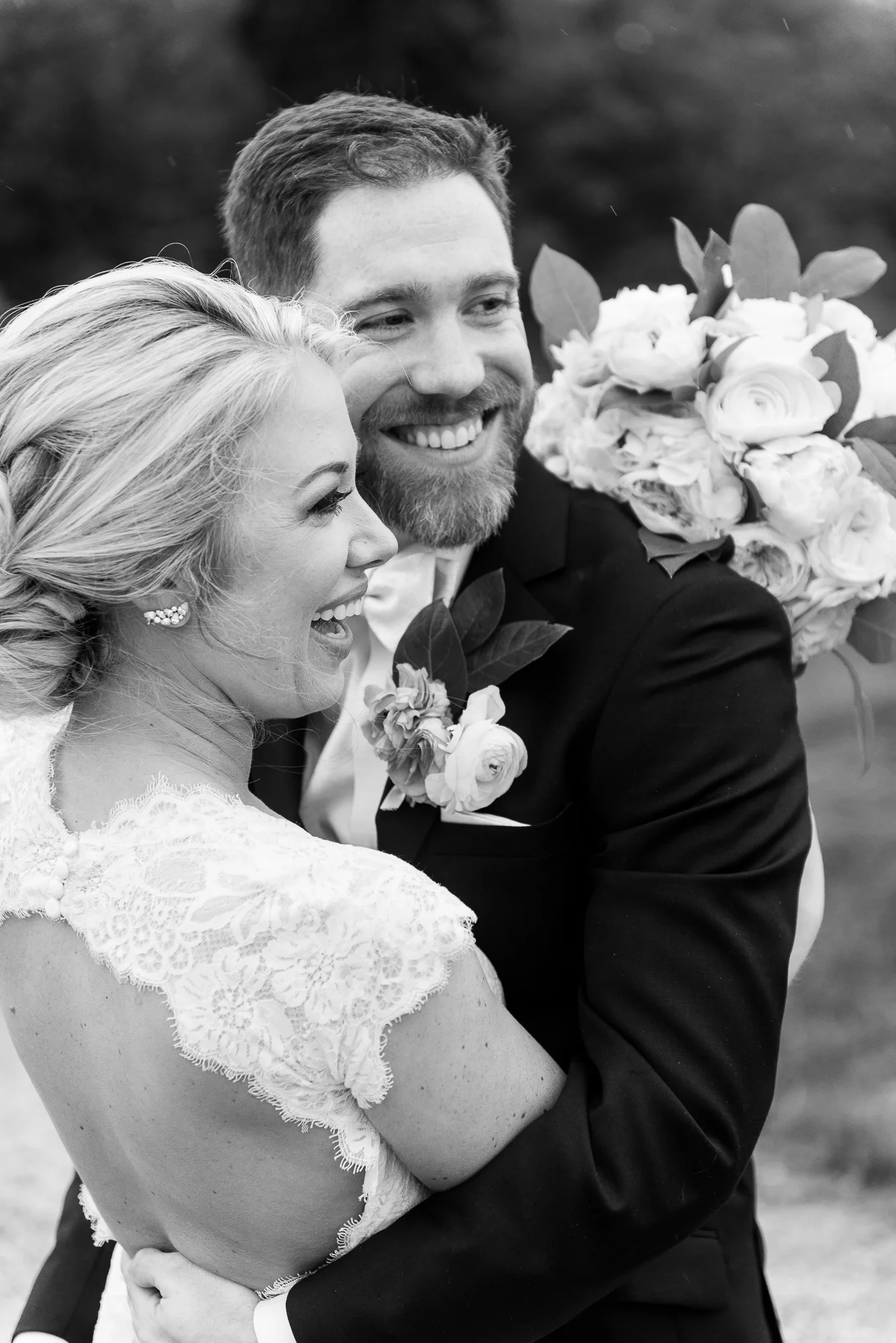 The bride and groom embrace and laugh outside Keswick Vineyards in Charlottesville, Virginia
