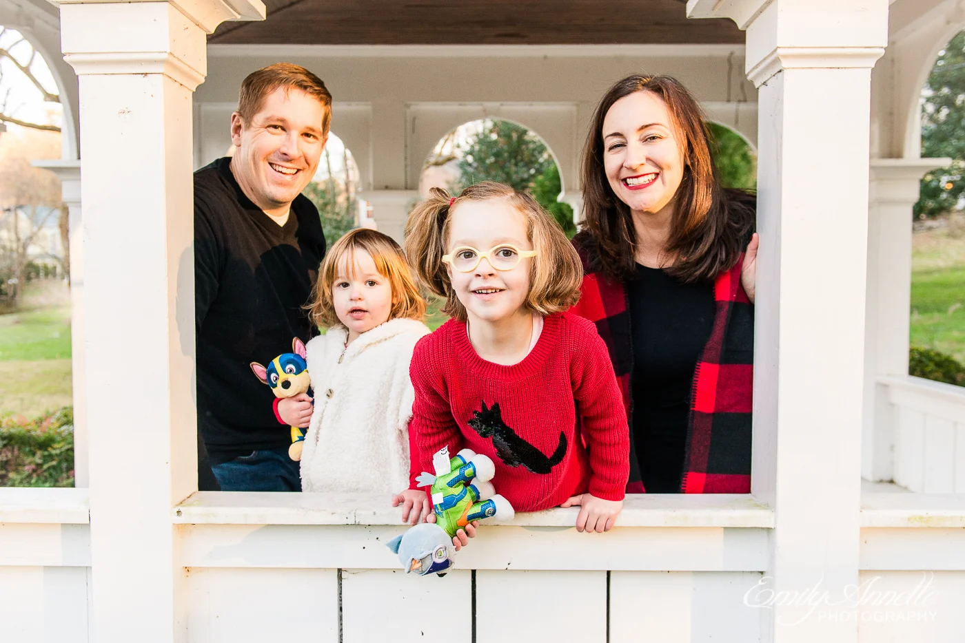 A family with two little girls posing for a photo at Clifton Town Park in Fairfax County, Virginia