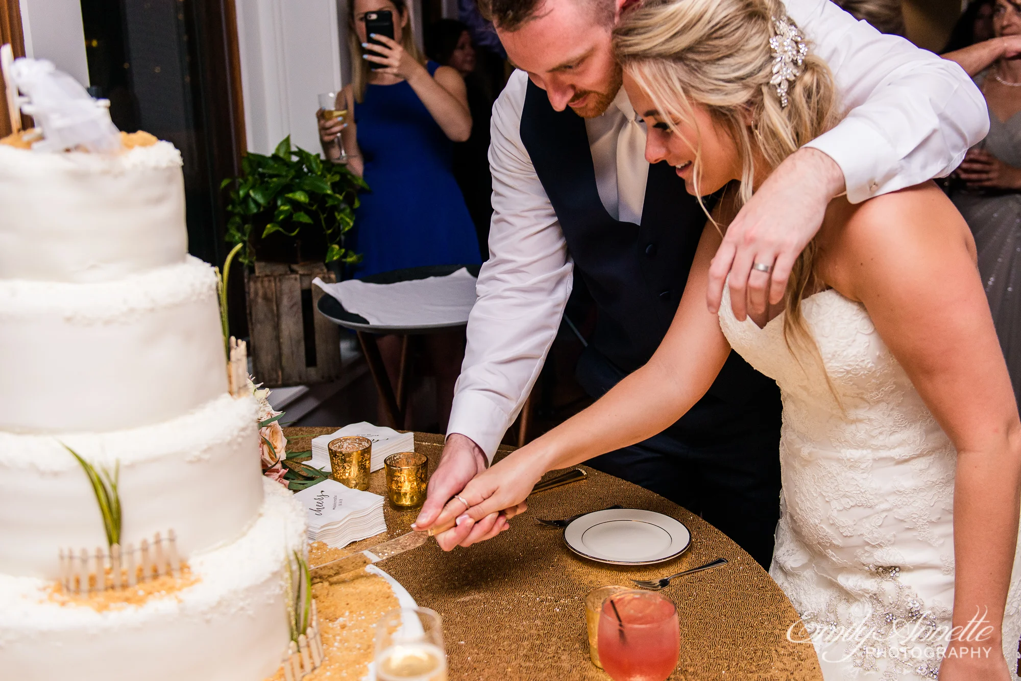 A bride and groom cut their wedding cake during their reception at Herrington on the Bay in North Beach, Maryland