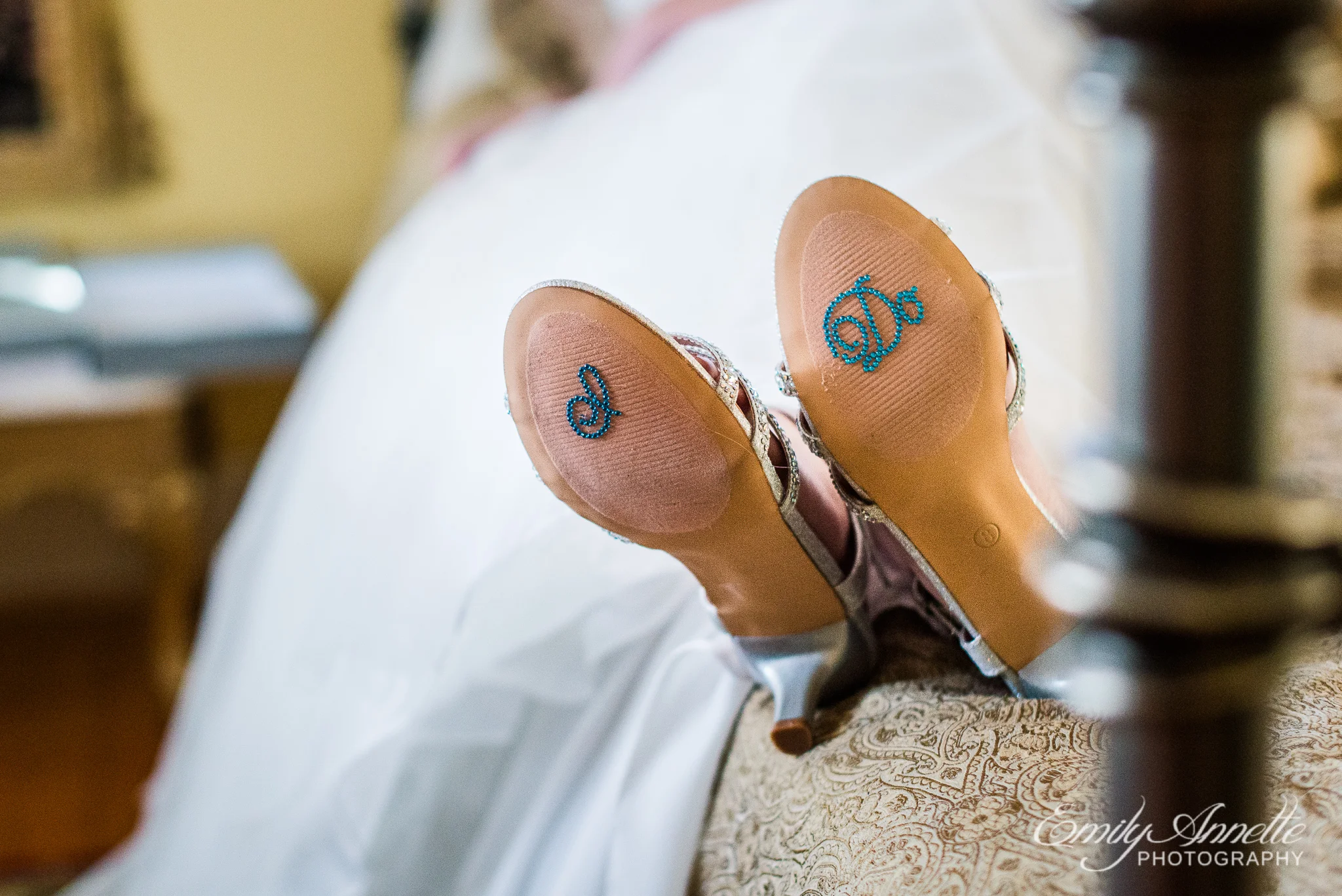 A bride shows off the soles of her shoes decorated with blue rhinestones that spell I Do before her wedding ceremony at Amber Grove near Richmond, Virginia