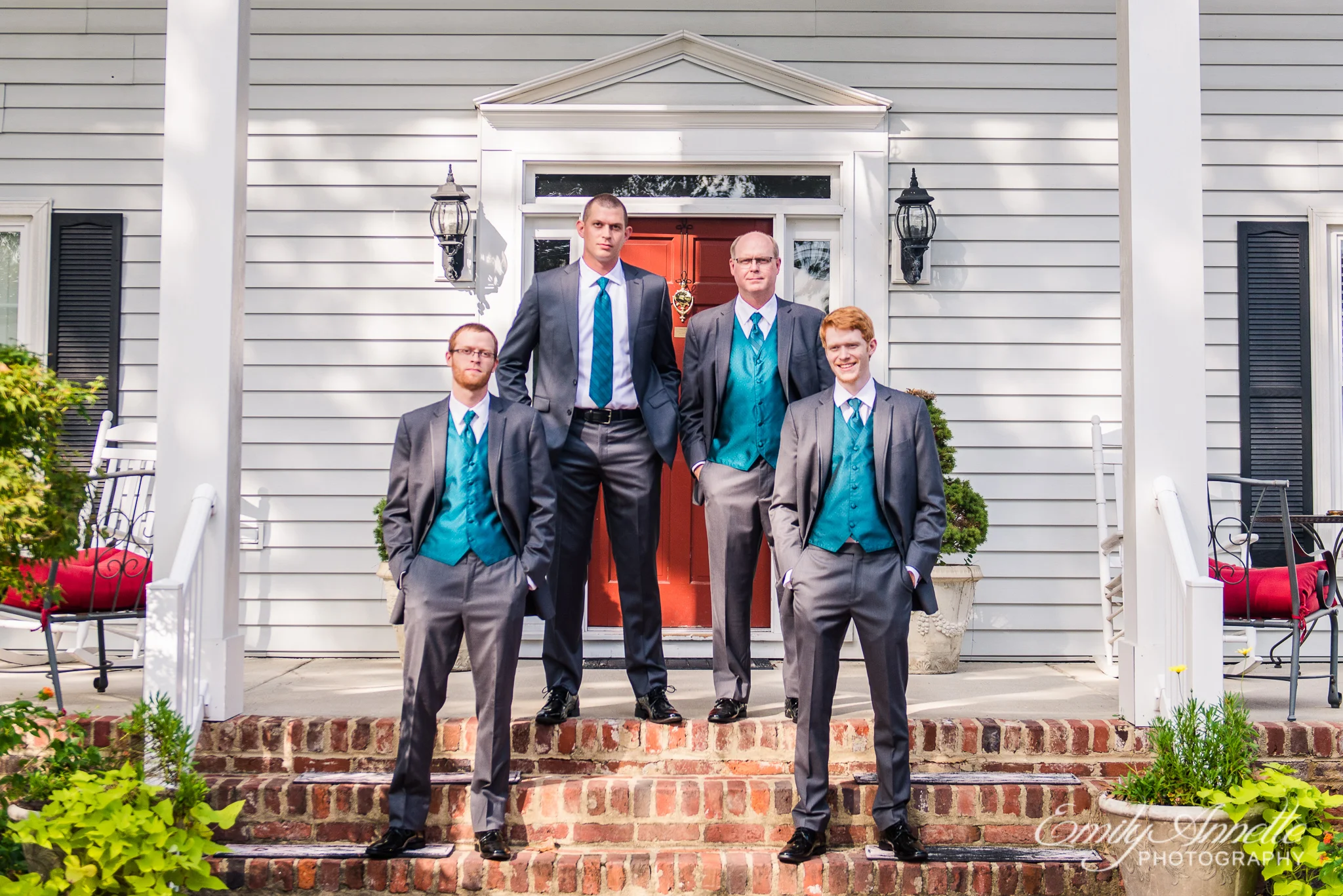 A groom and his groomsmen pose on the front porch of a historic house during a country wedding at Amber Grove near Richmond, Virginia