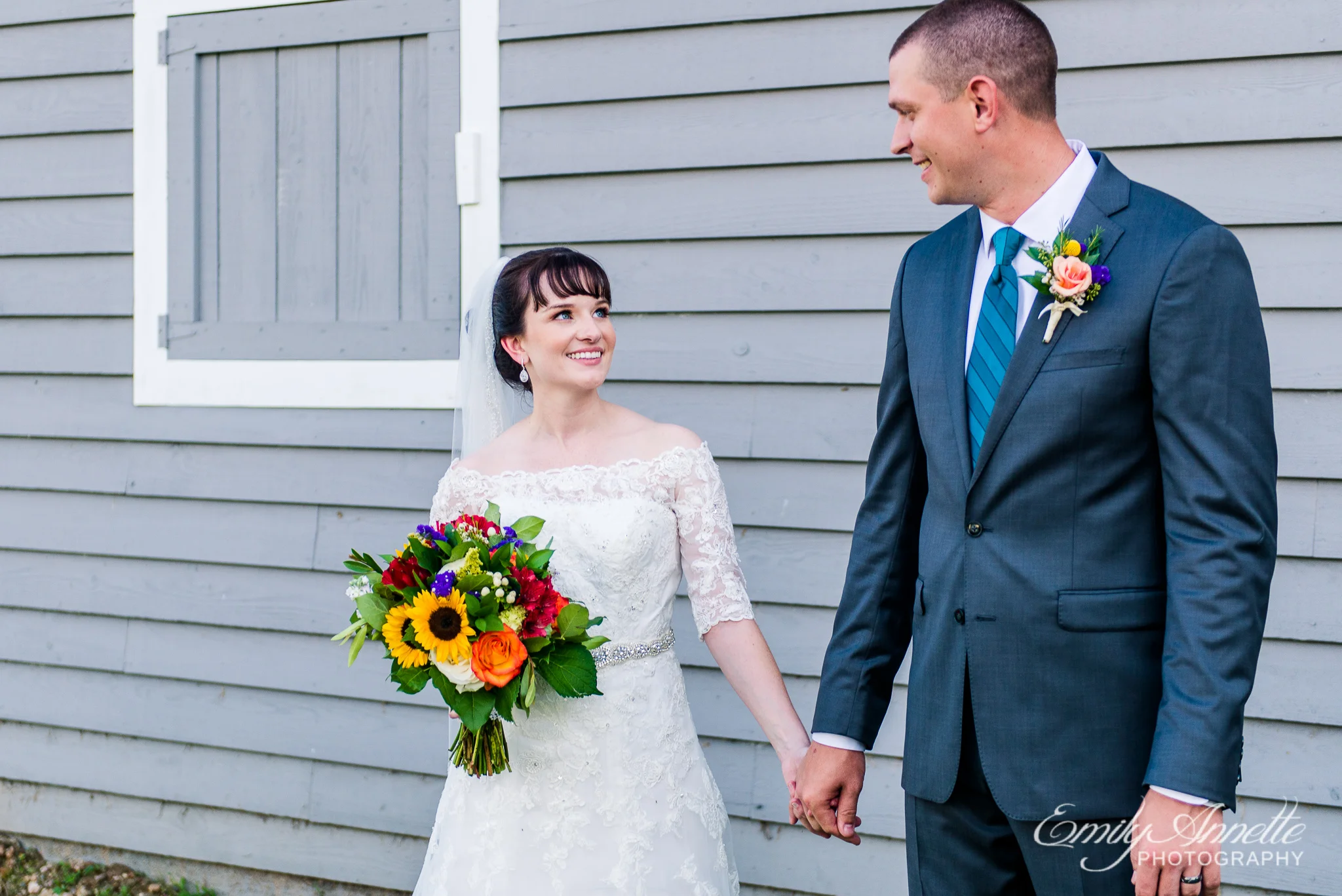 A bride and groom hold hands and smile at each other after their country wedding at Amber Grove near Richmond, Virginia