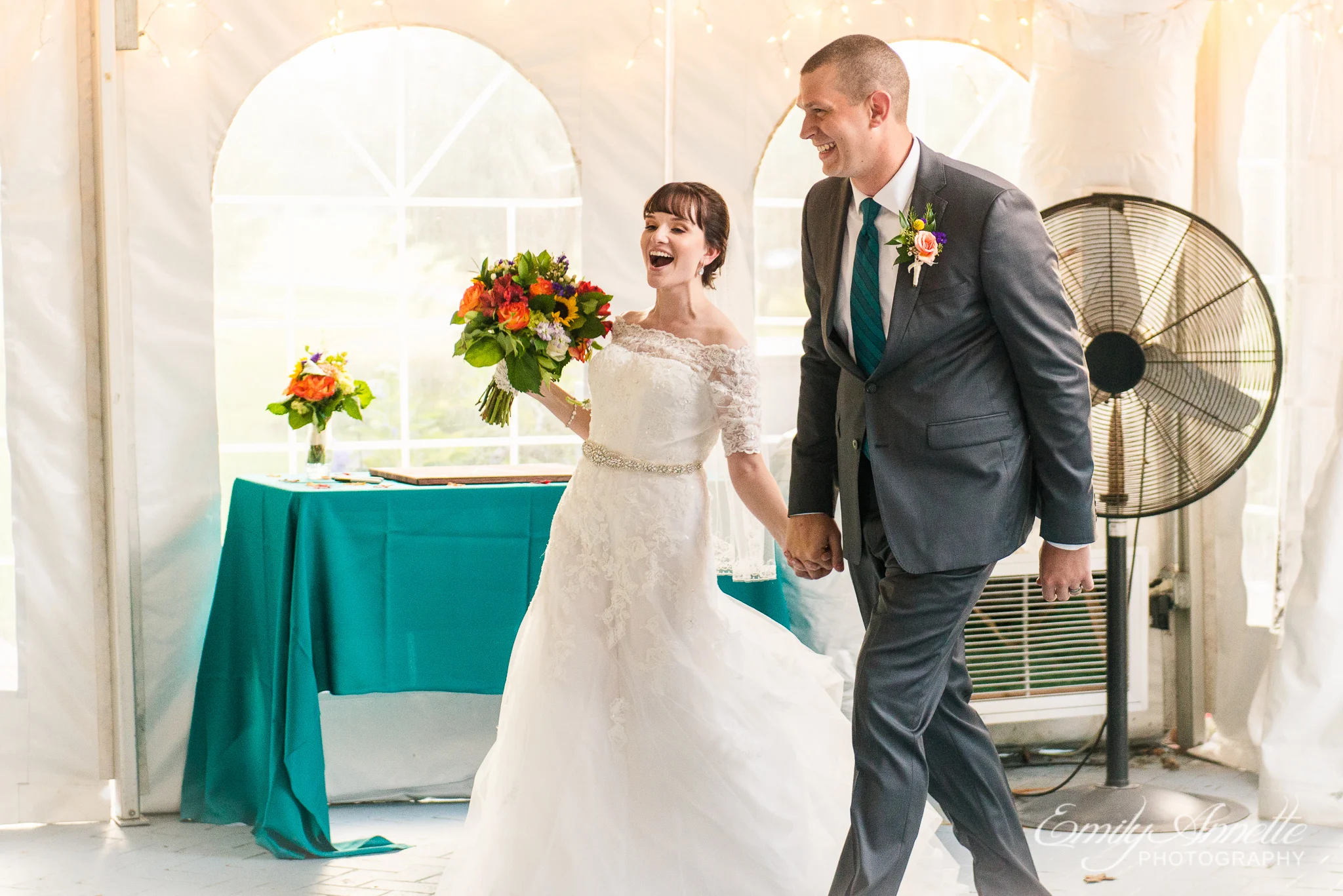 A bride and groom joyfully enter their country wedding reception at Amber Grove near Richmond, Virginia