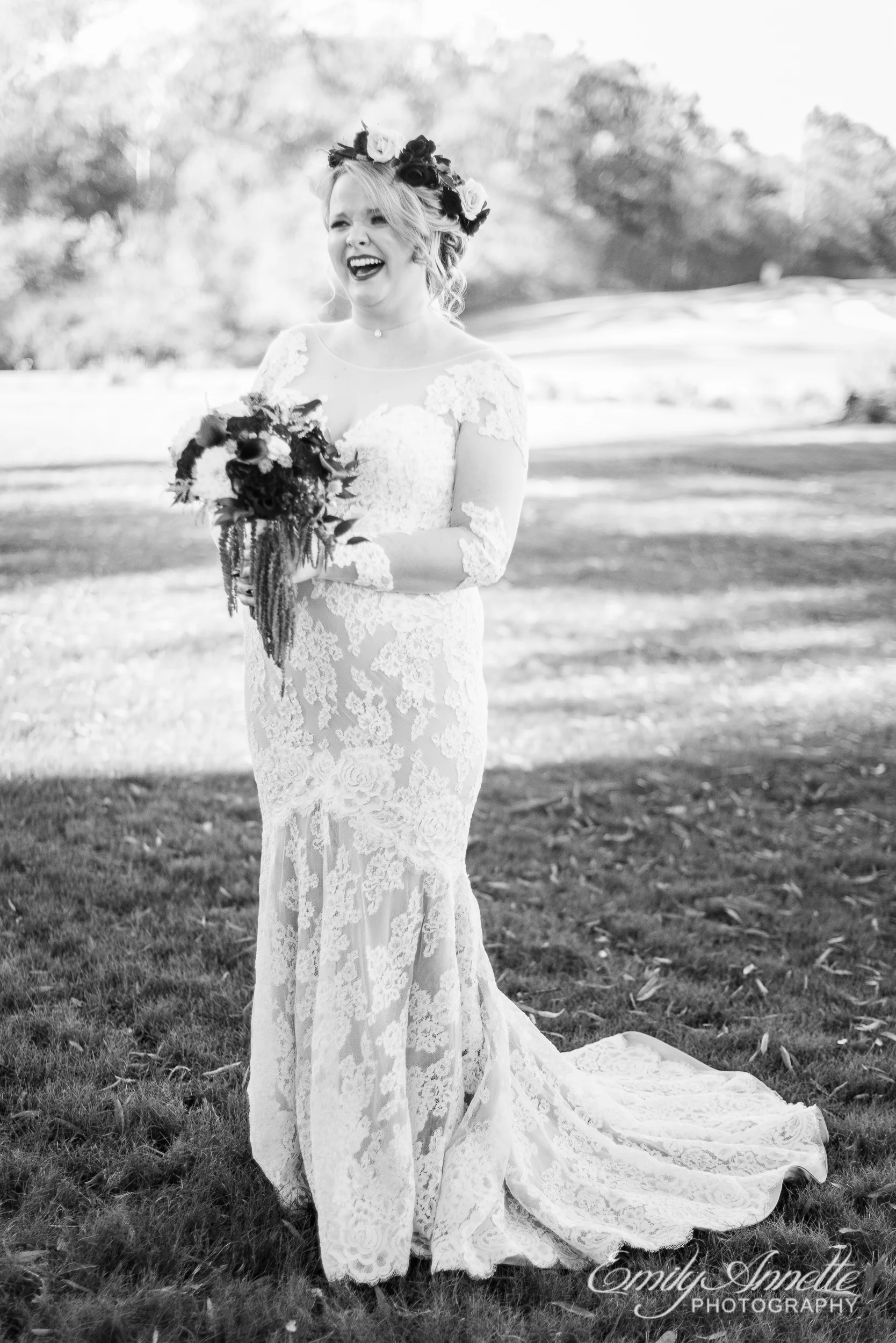 A bride wearing a lace wedding dress with sleeves and a flower crown holding her bridal bouquet on the golf course at Willow Oaks Country Club in Richmond, Virginia